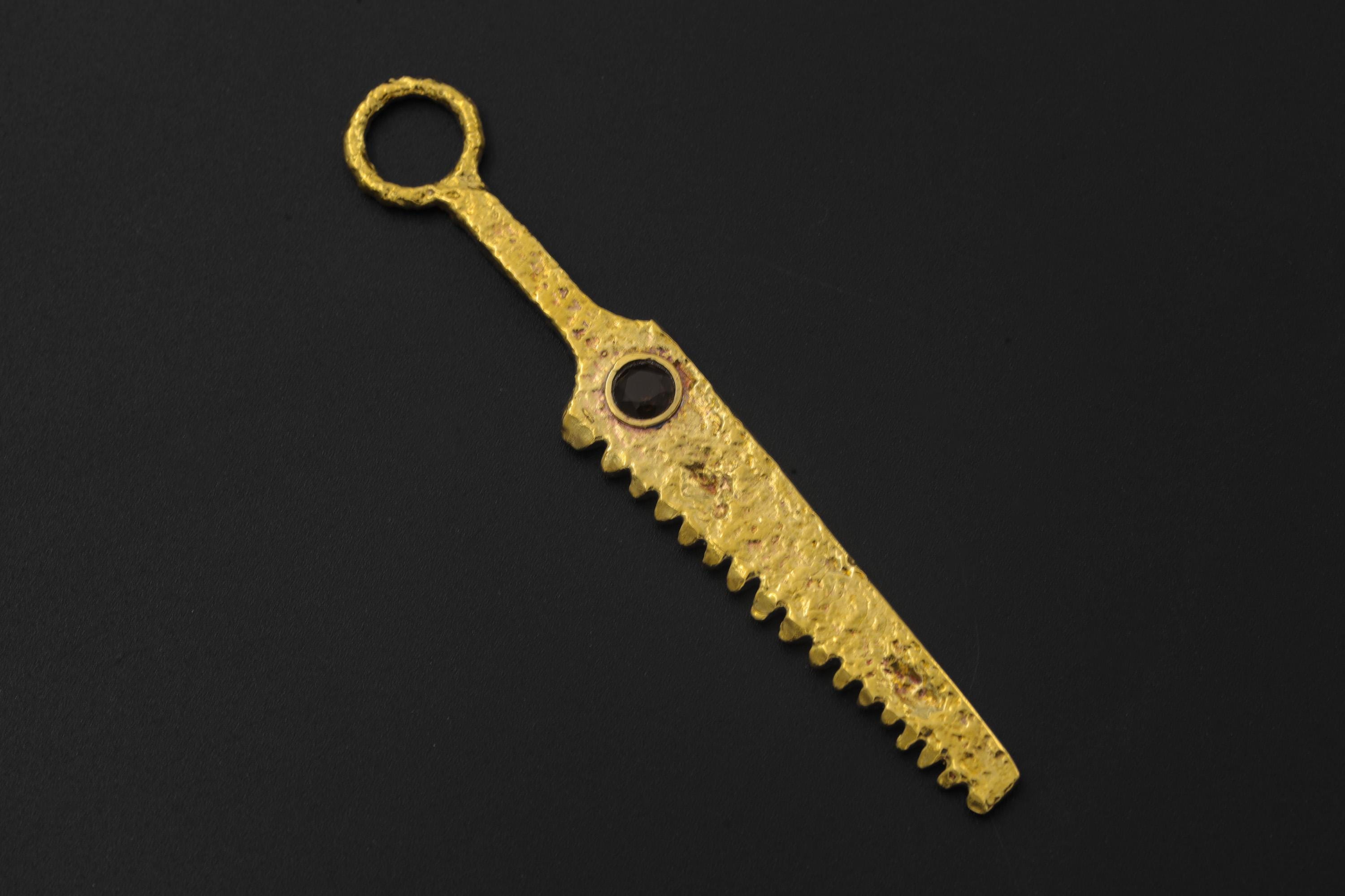 Smoky Quartz cutter spoon pendant displayed on black background with serrated gold-plated form.