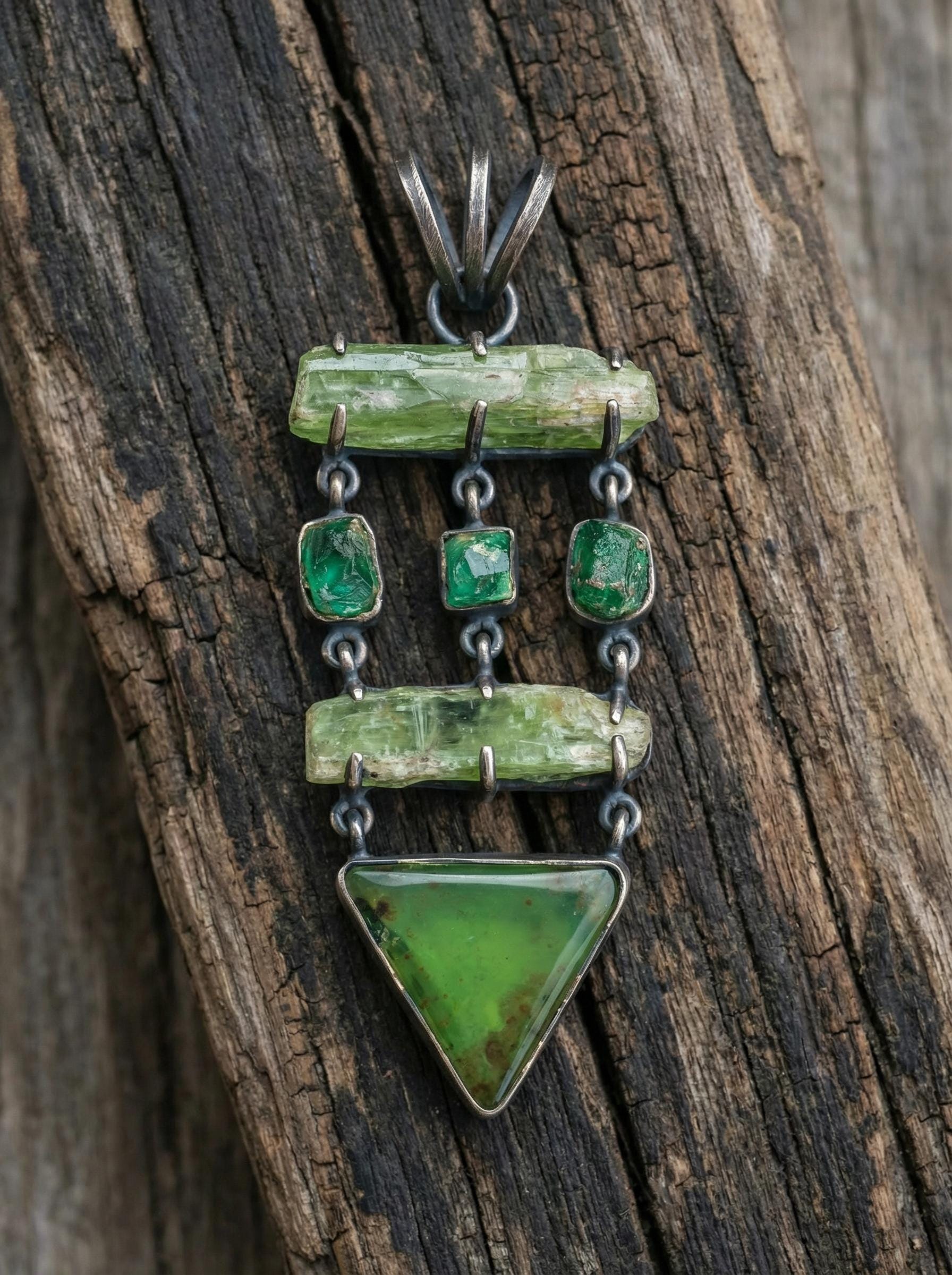 Green Kyanite Emerald Chrysoprase pendant shown on rustic wood, with raw Kyanite, vivid Emeralds, and triangular Chrysoprase.