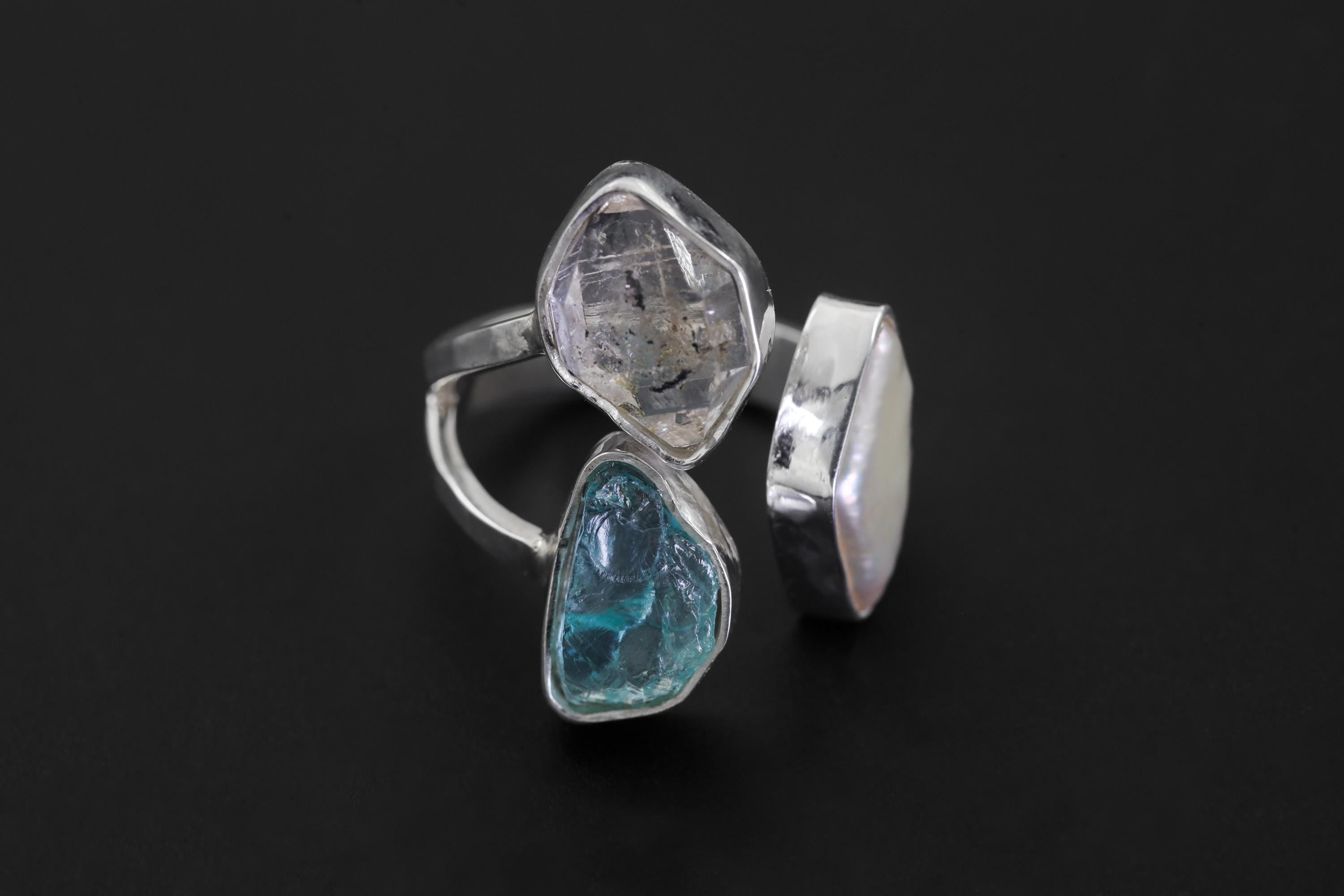 Close-up of adjustable sterling silver ring with Herkimer Diamond crystal, marquise Pearl, and raw Blue Apatite stones.
