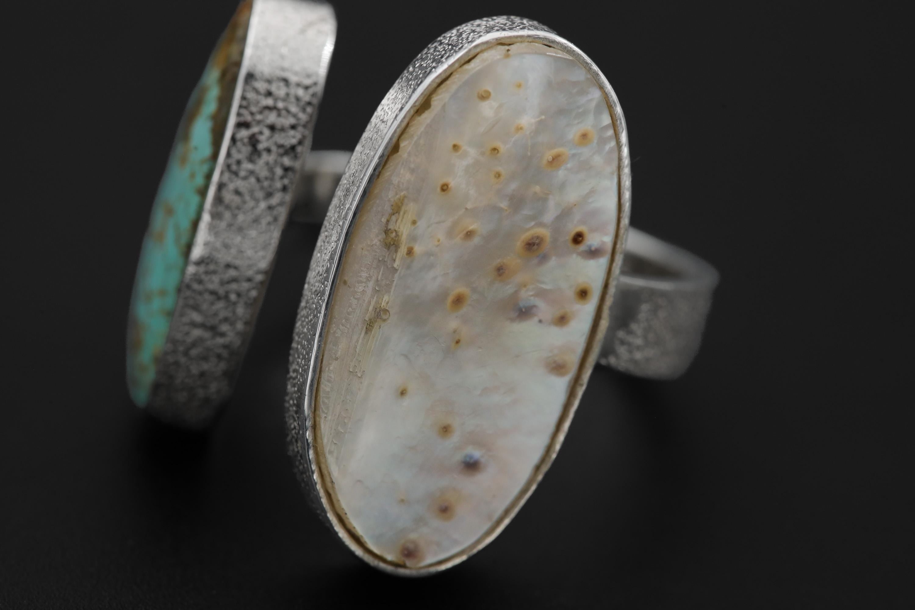 Close-up of Mother of Pearl and Turquoise ring showing creamy shell cabochon and blue-green matrix stone.