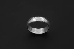 Sterling silver hammered band displayed on dark background with simple polished ring profile.