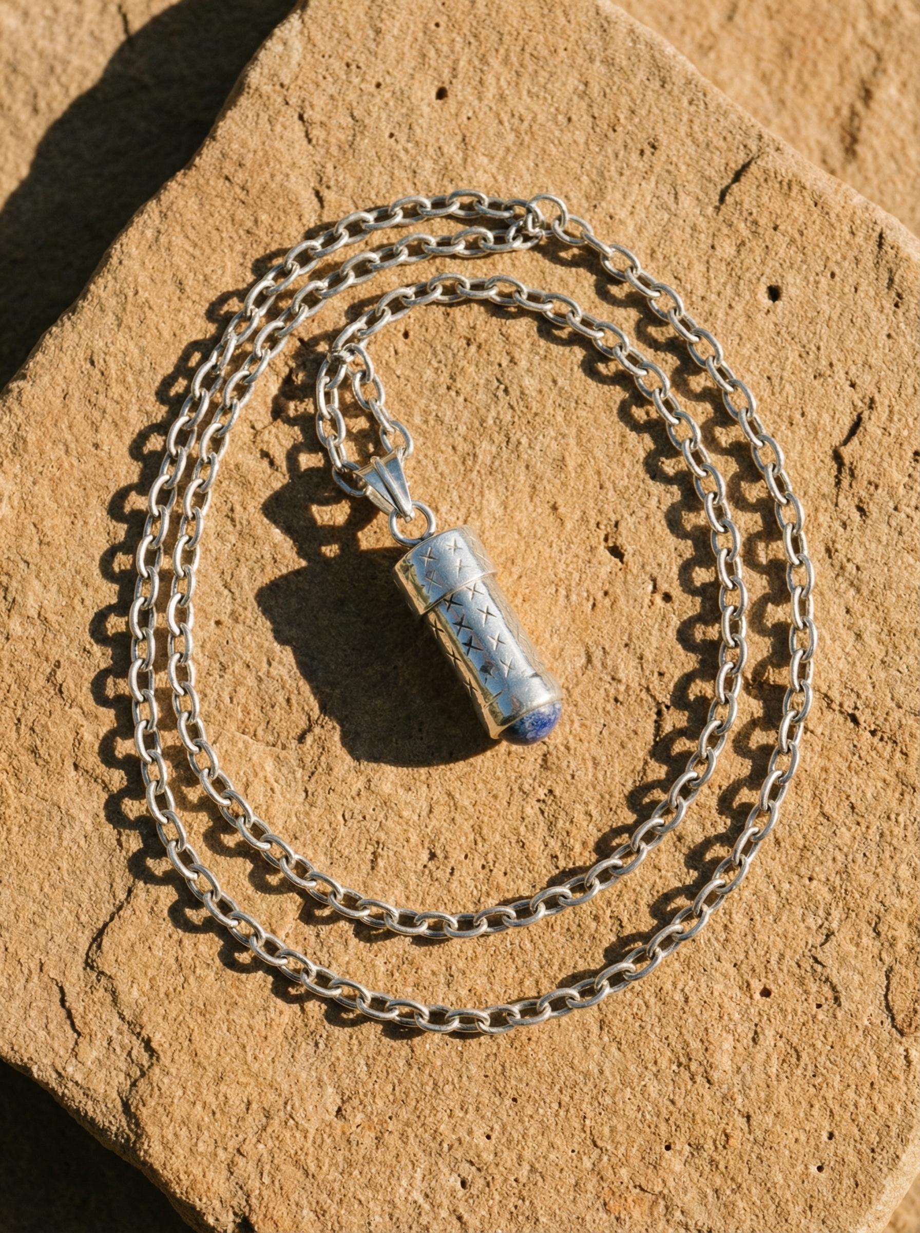 Lapis Lazuli keepsake pendant shown on slate with sterling silver chain and deep blue stone base.