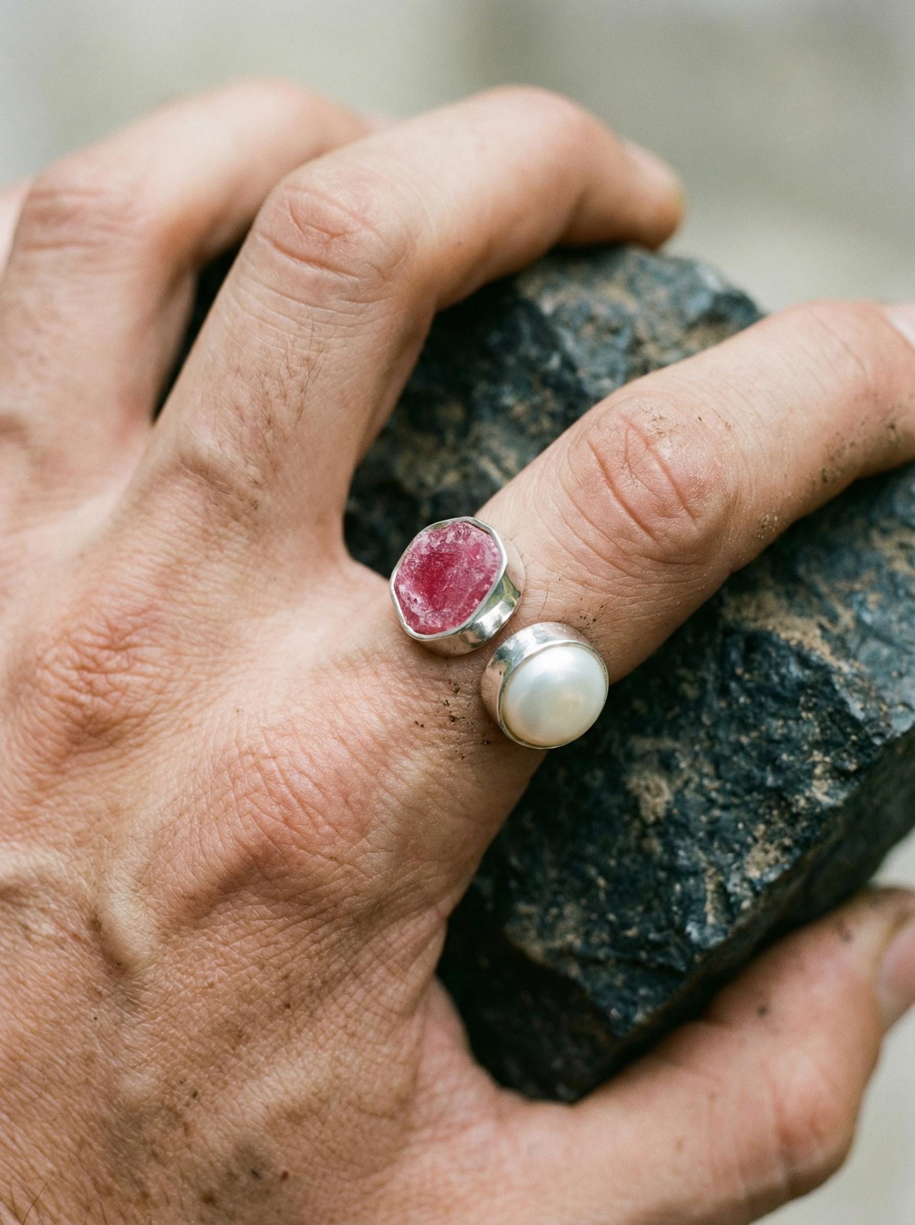 Close-up of natural Ruby cabochon and South Sea Pearl cabochon in bezel-set 925 sterling silver with hammered texture.