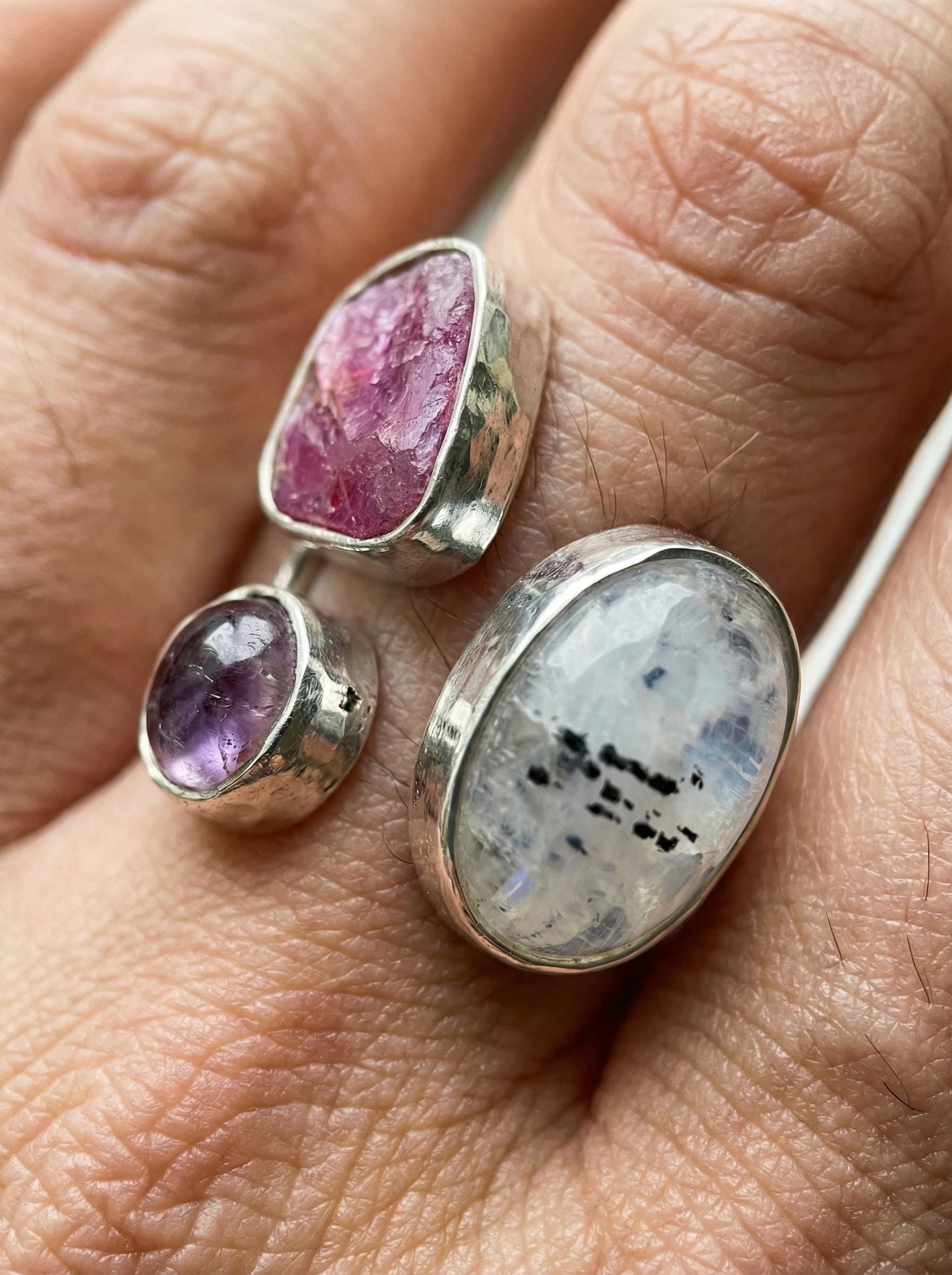 Inner Flame Multi Stone Ring shown worn on hand with Blue Moonstone, Ruby, Amethyst, and adjustable sterling silver band.
