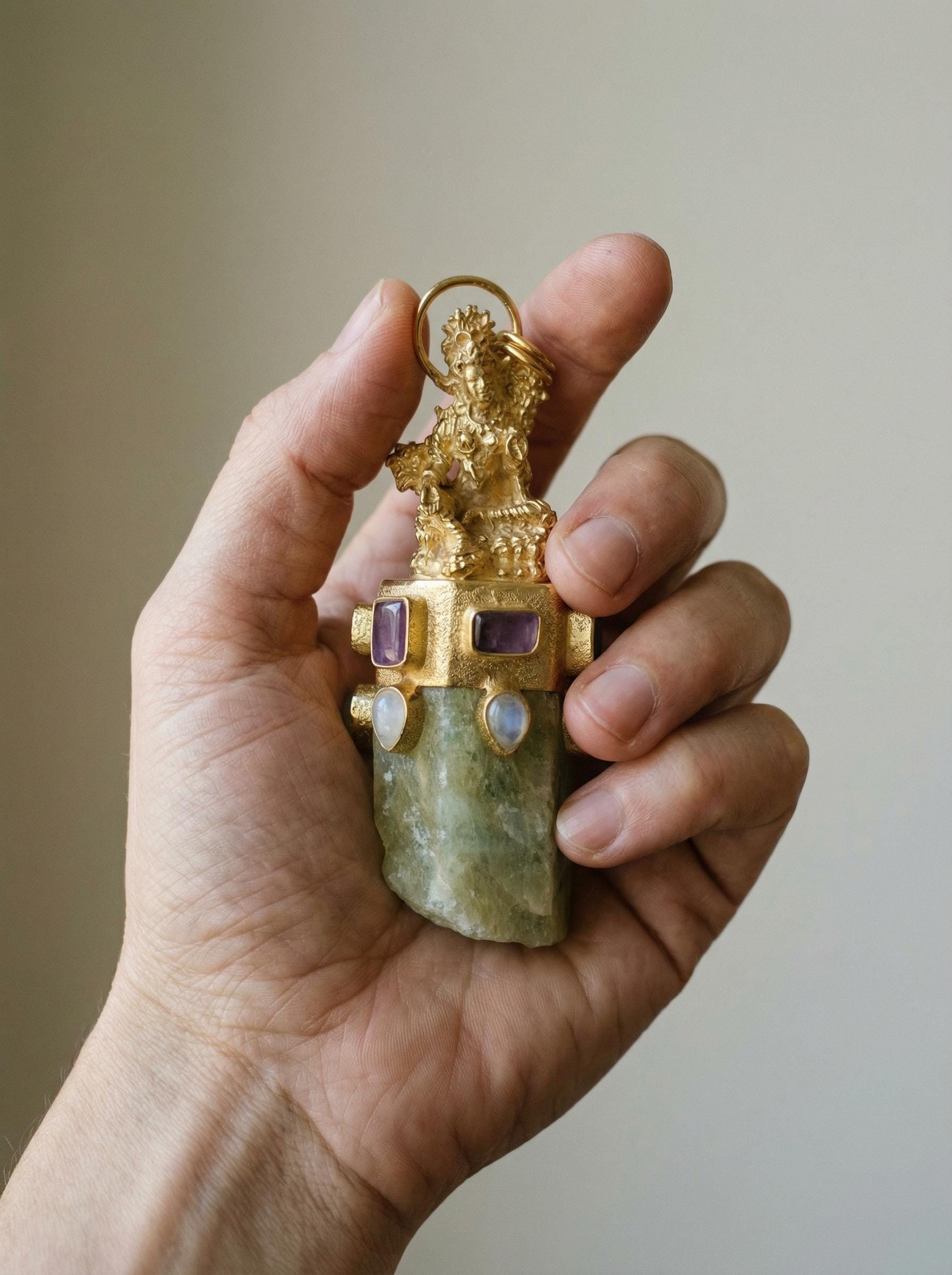 Praying Sarasvati Aquamarine Amethyst Moonstone pendant shown held in hand as a 8 cm gold-plated statement talisman.