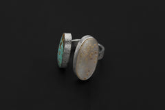 Tide and Shell Mother of Pearl Turquoise ring shown on dark background with opposing bezel-set stones.