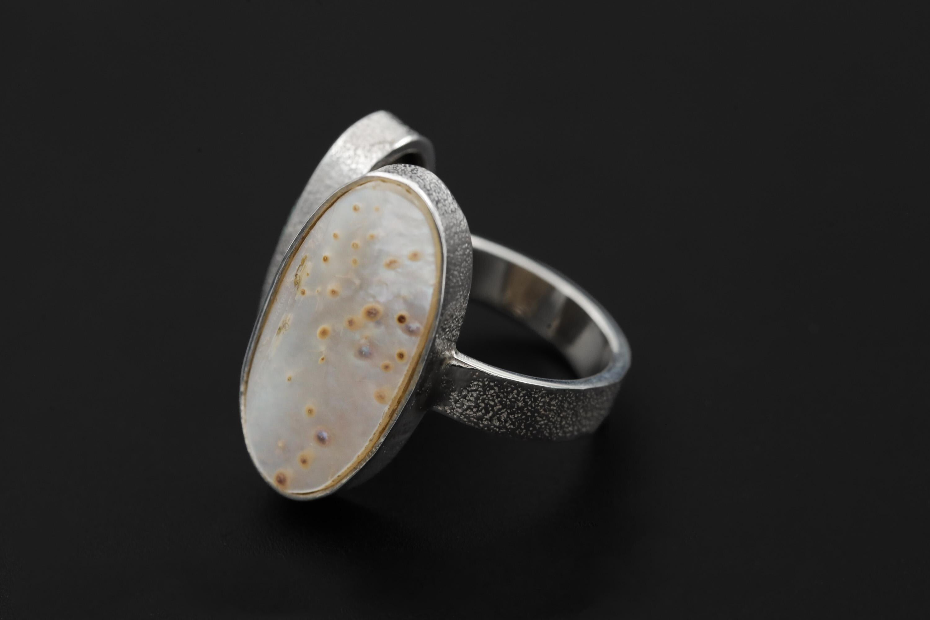 Mother of Pearl Turquoise adjustable ring shown from the side with organic textured sterling silver setting.
