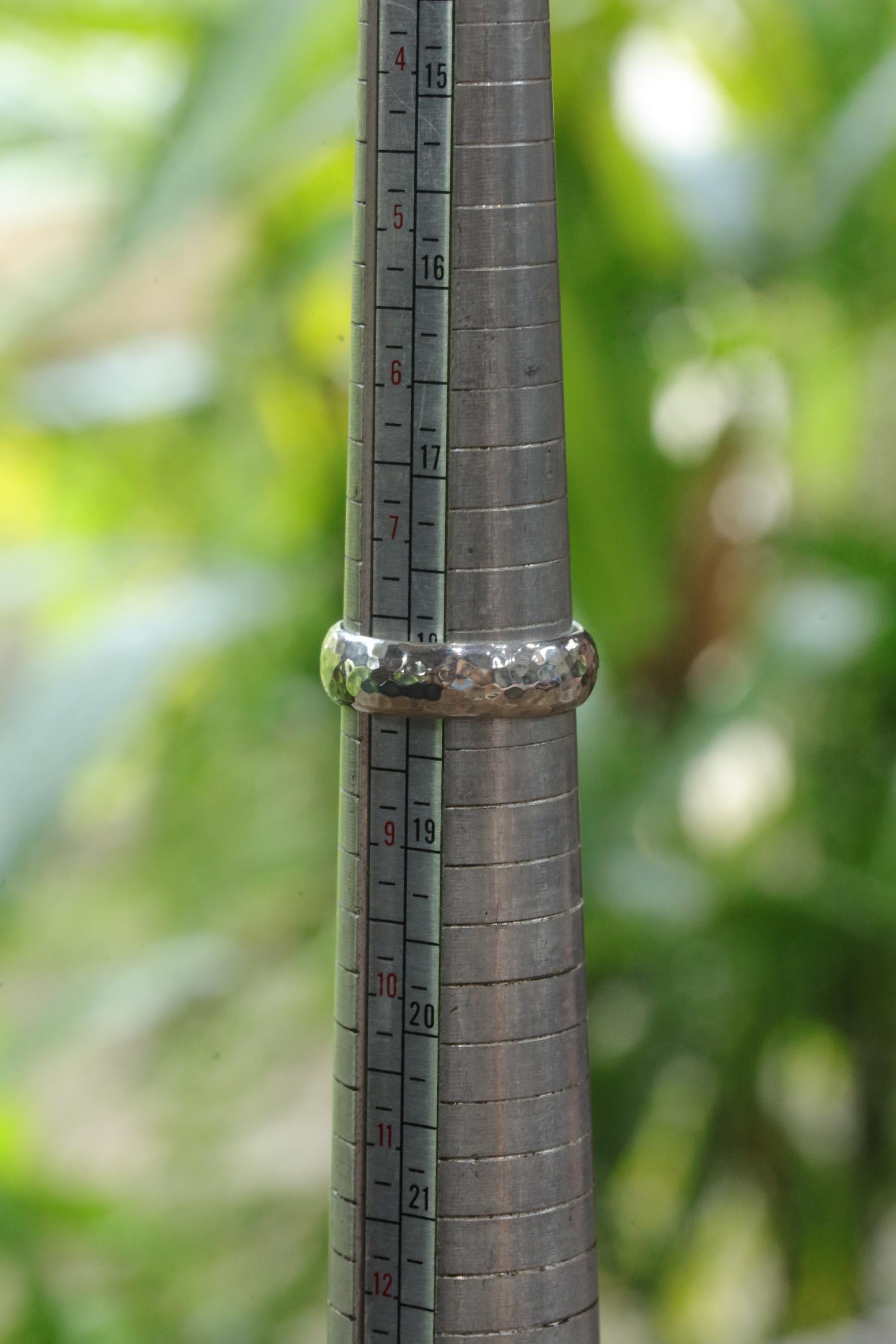 Hammered sterling silver ring shown on mandrel for US size 8 reference.
