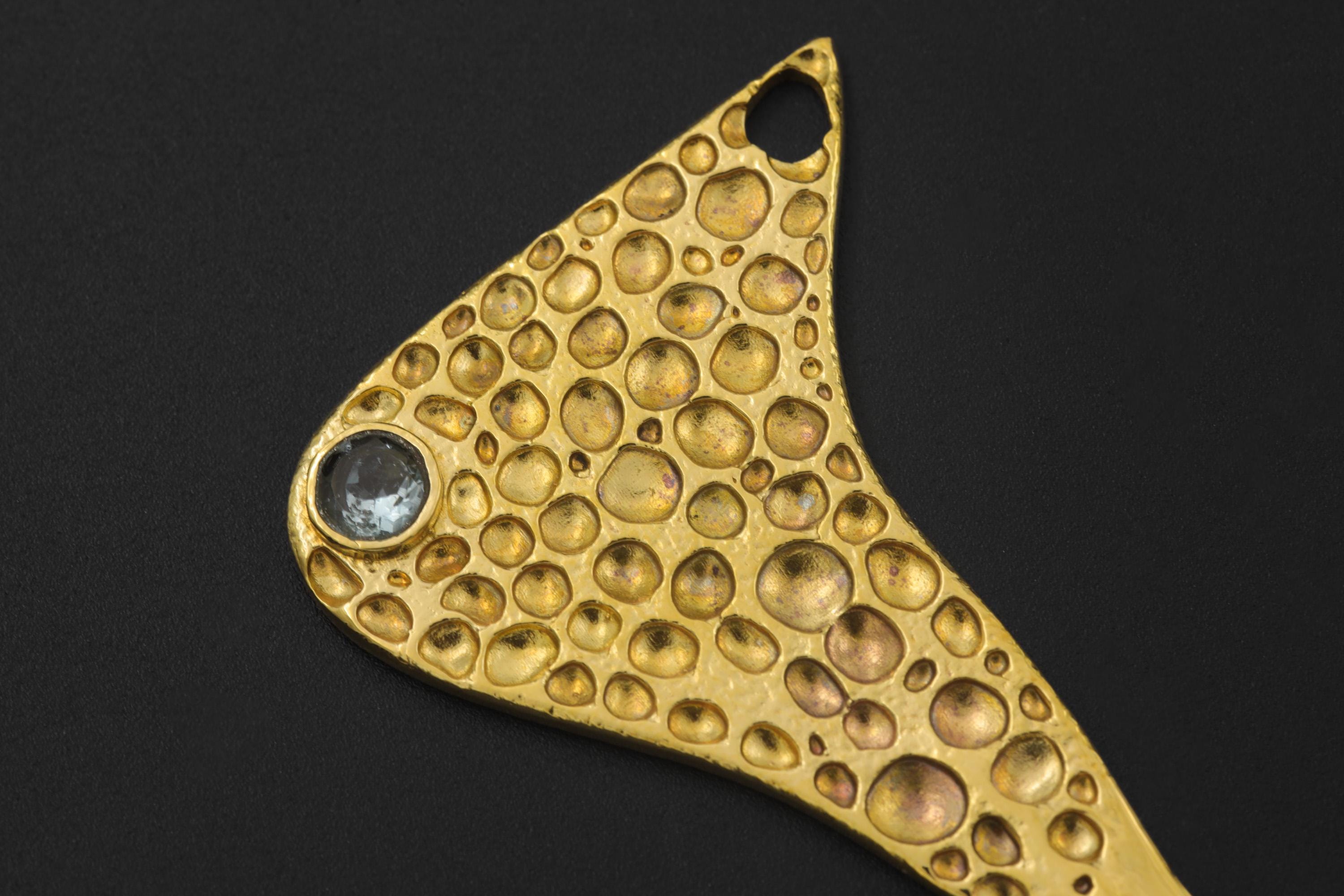 Close-up of Blue Topaz spoon pendant showing textured gold-plated brass and faceted stone detail.