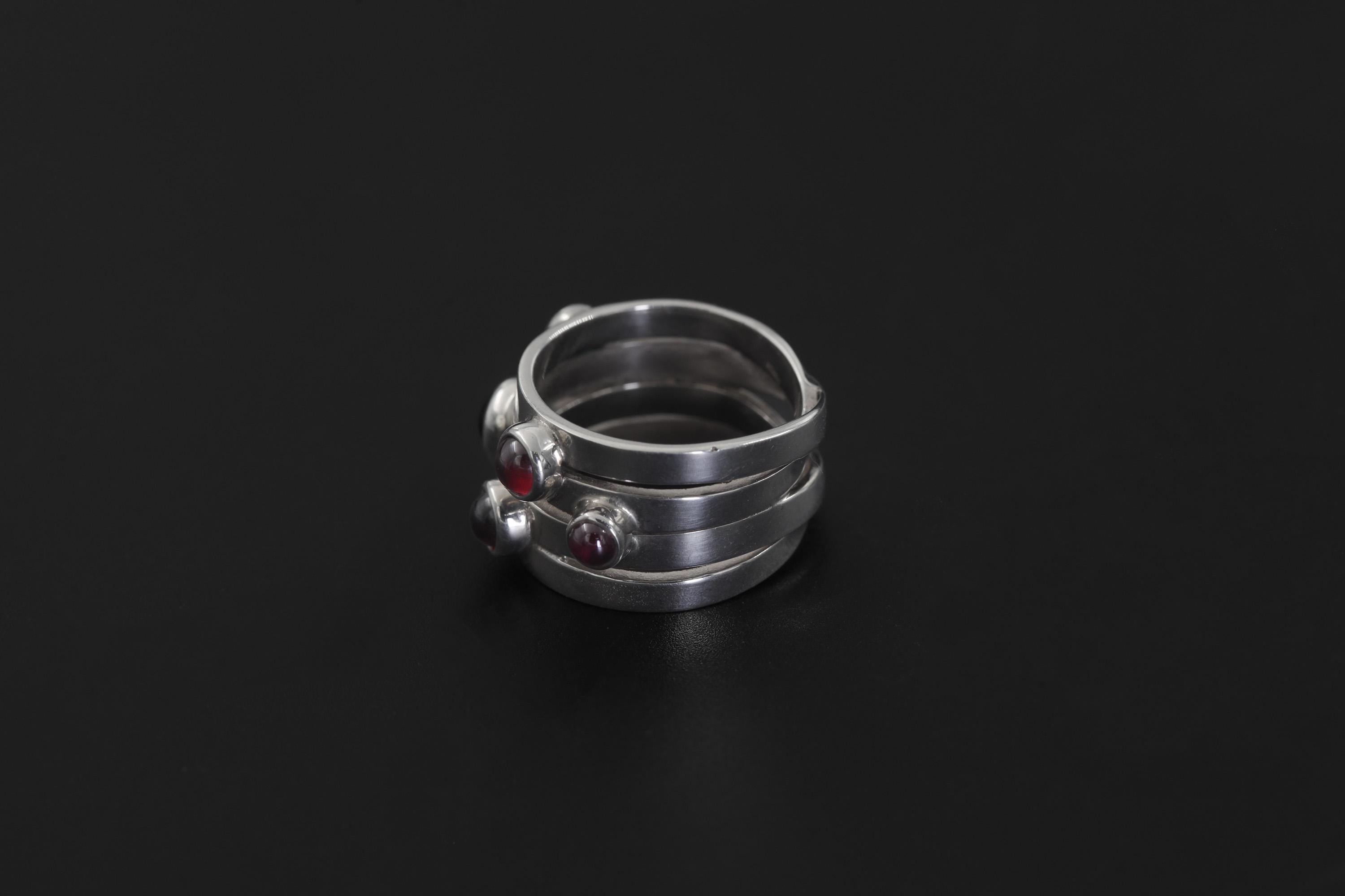 Five Stone Garnet Ring displayed on dark background with polished silver bezel settings.