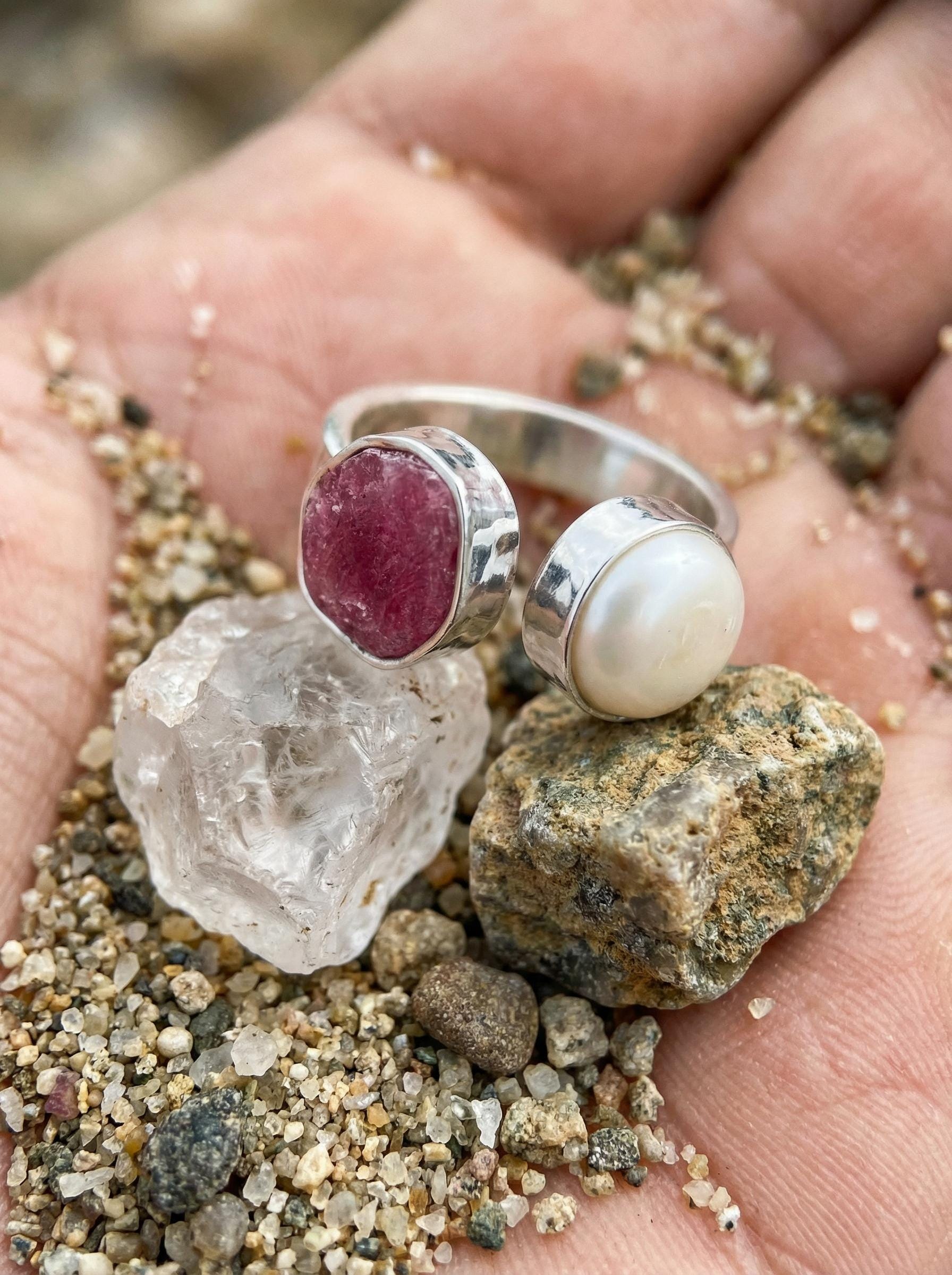 Ruby South Sea Pearl ring shown in hand with crystal styling, highlighting the red gemstone and luminous white Pearl contrast.