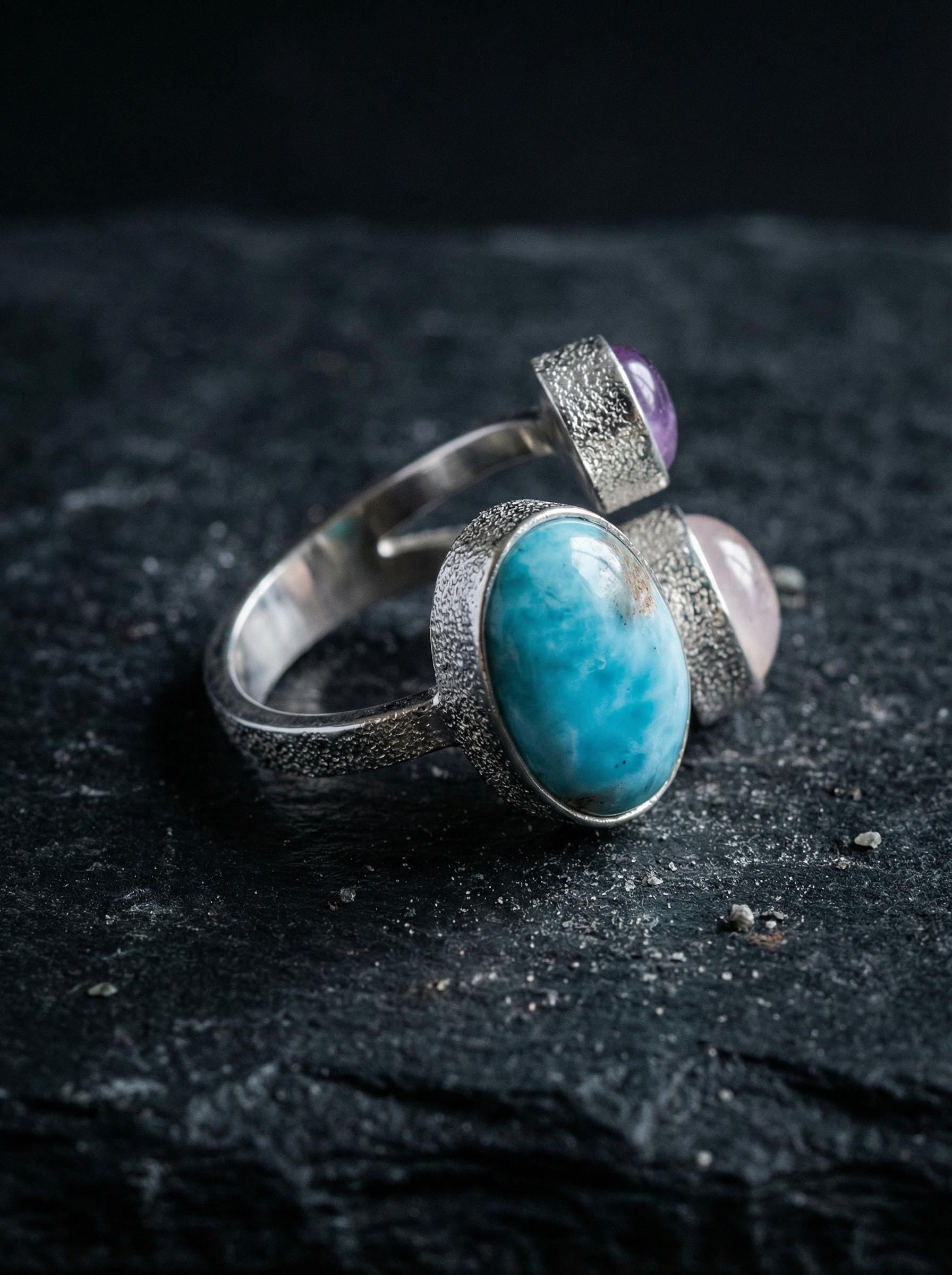 Ocean Heart Multi Stone Ring shown on black slate with three independent gemstone settings in polished sterling silver.