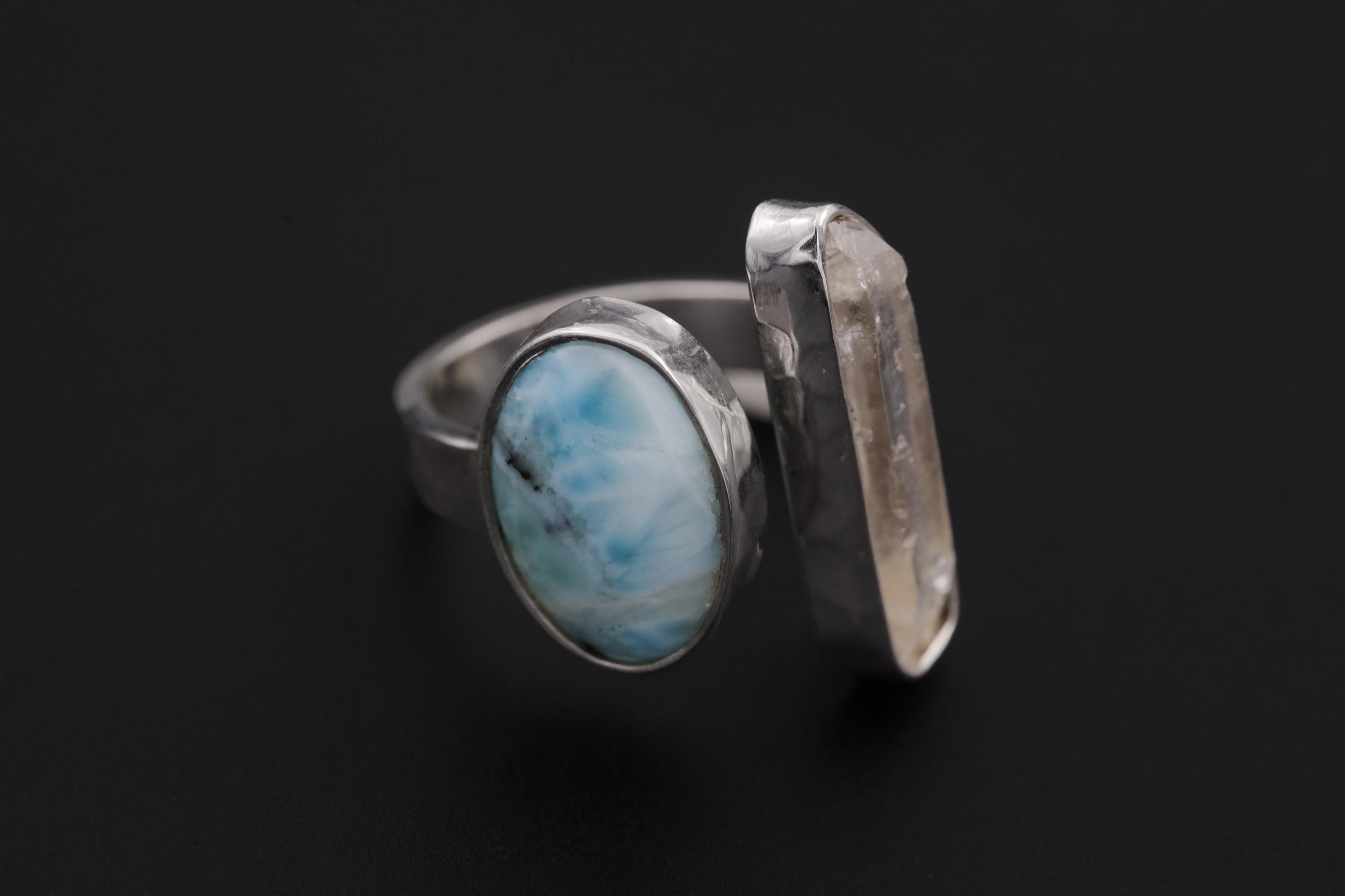 Horizon Flow Quartz and Larimar Ring shown on black background with clear Quartz crystal and ocean-blue Larimar cabochon.