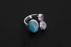 Ocean Heart Multi Stone Ring shown on black background with three bezel-set gemstones and adjustable silver band.