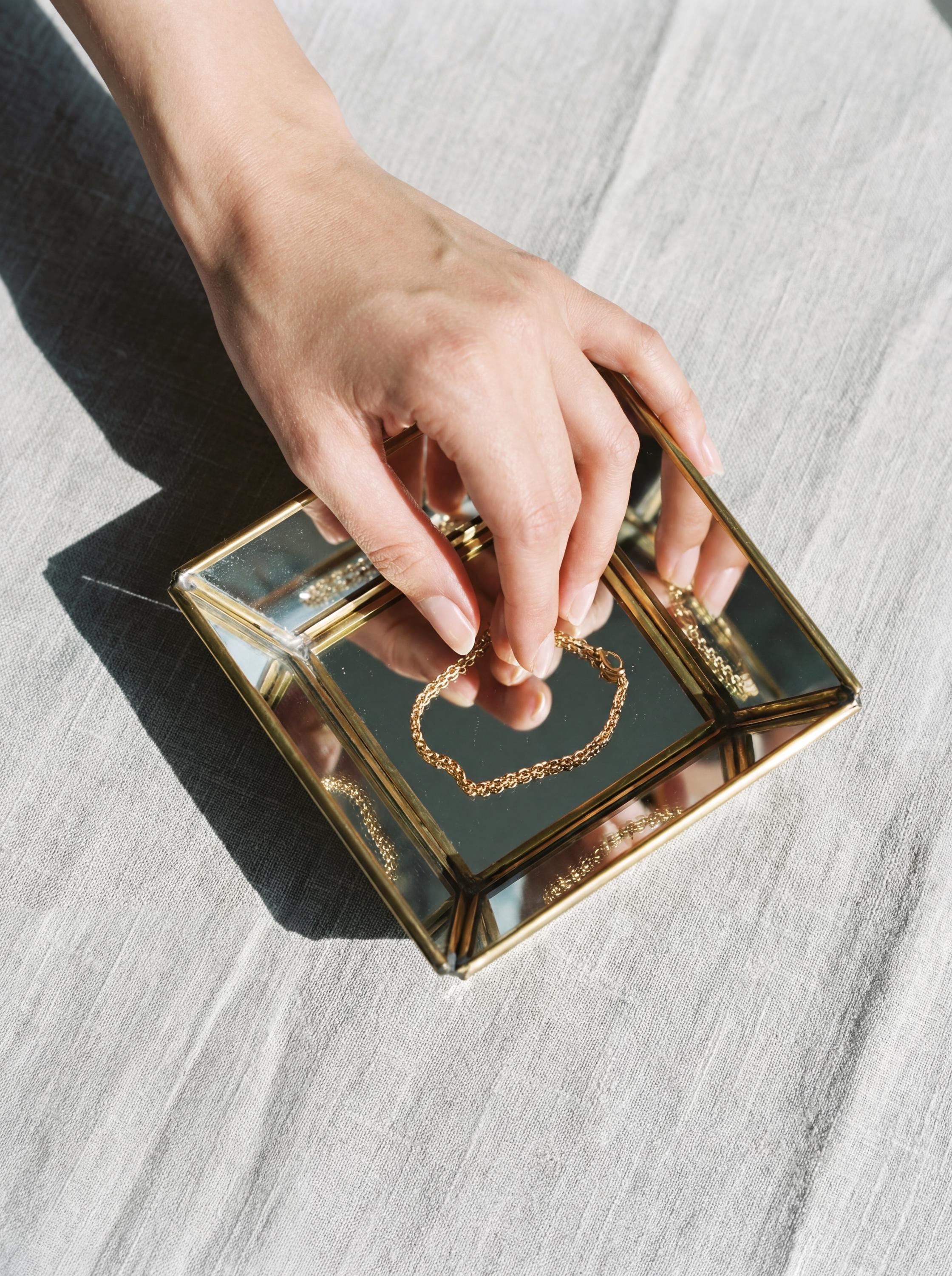 Brass mirror tray styled with jewelry, showing reflective angled sides and handmade soldered metal frame.