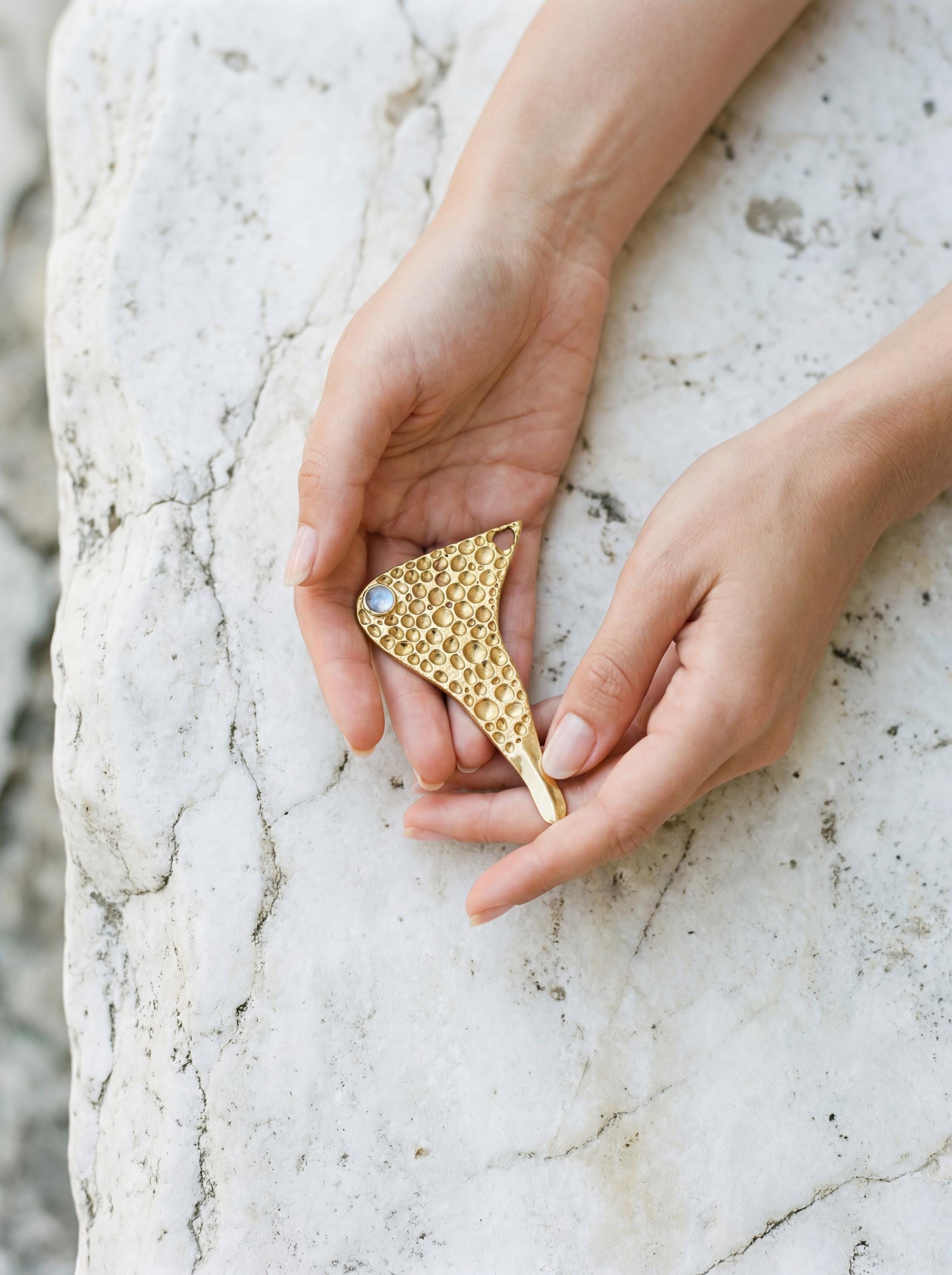 Golden ritual spoon pendant with Blue Moonstone shown worn as a sculptural necklace.