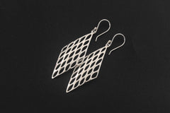 Sterling silver lattice earrings displayed on dark stone with open diamond-shaped geometric design.