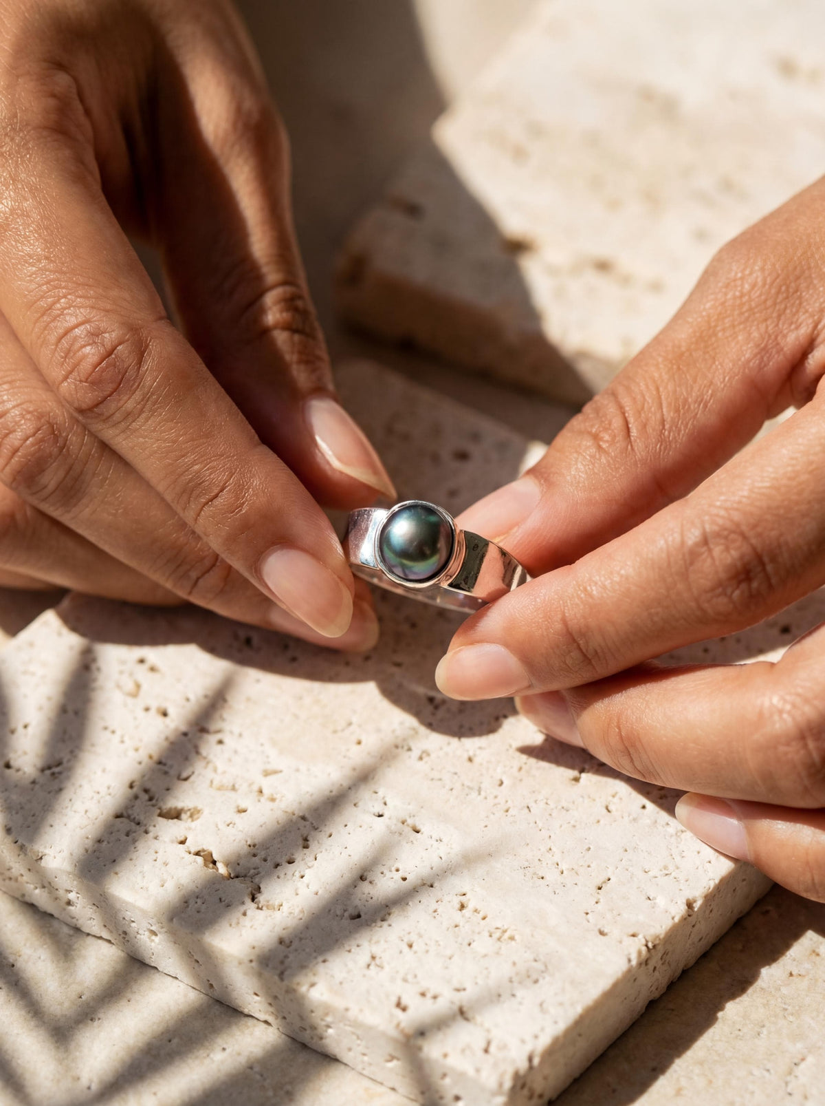 Midnight Luster Black Pearl Ring shown worn on hand with hammered sterling silver band and dark organic Pearl.