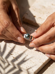Midnight Luster Black Pearl Ring shown worn on hand with hammered sterling silver band and dark organic Pearl.