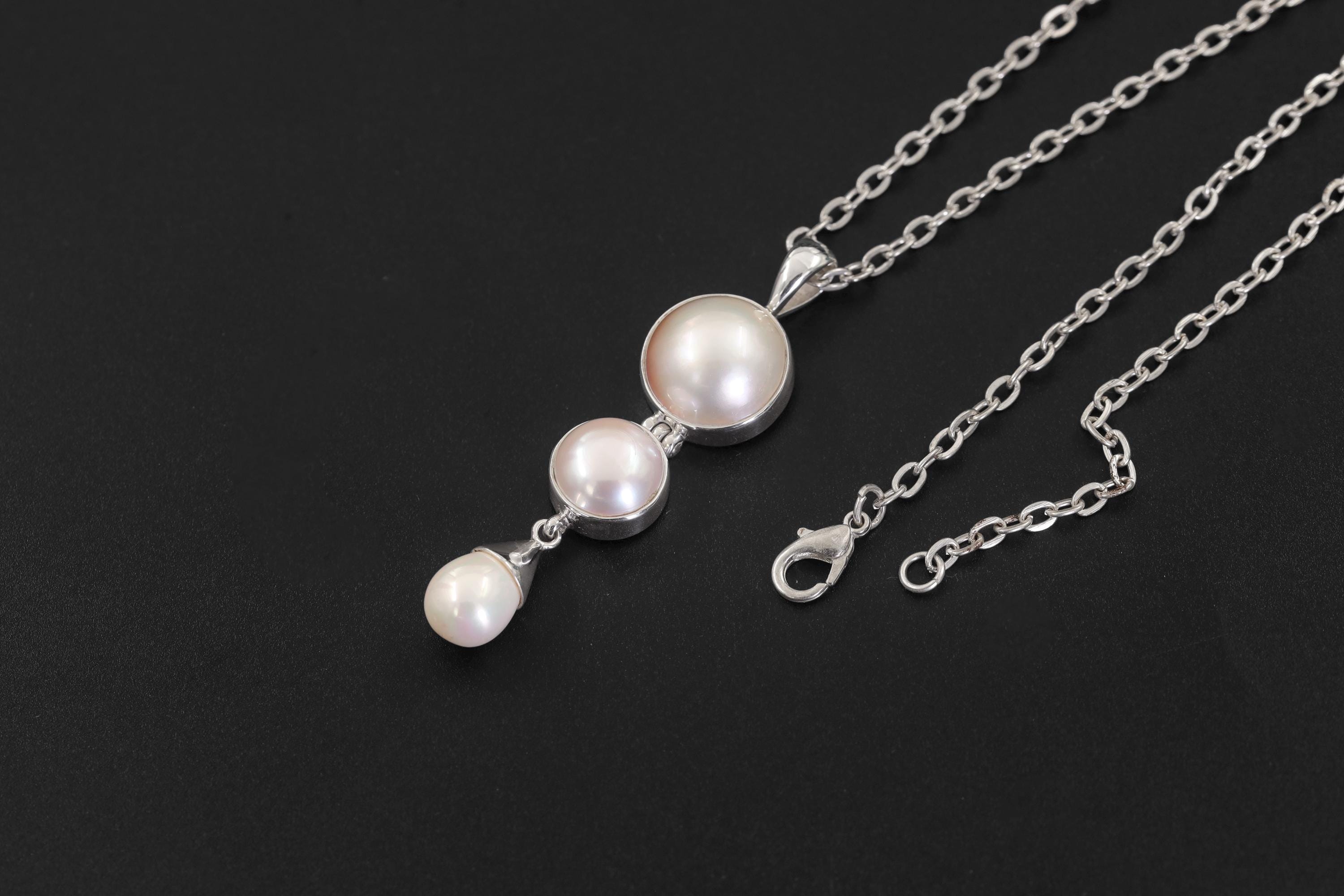 Lunar Cascade Pearl Pendant displayed on dark background with three natural cultured Pearls and silver chain.