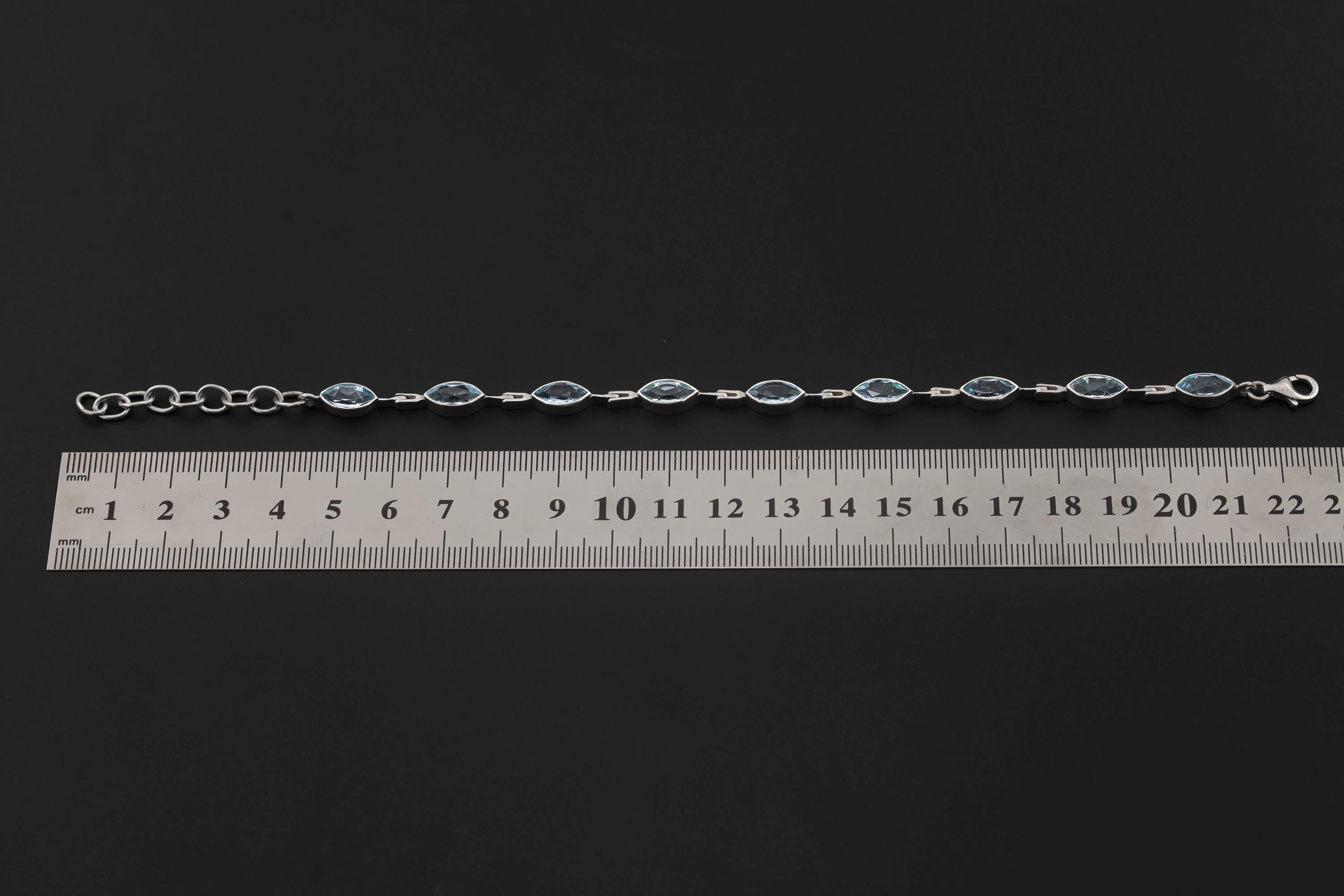 Blue Topaz sterling silver bracelet shown beside a ruler for approximately 22 cm length reference.
