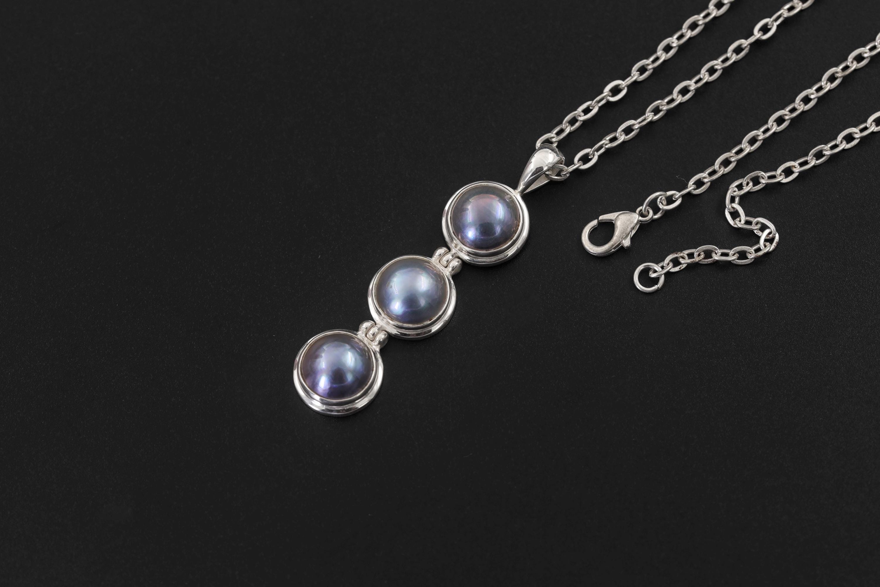 Black Pearl pendant displayed on dark background with sterling silver chain and vertical triple pearl design.