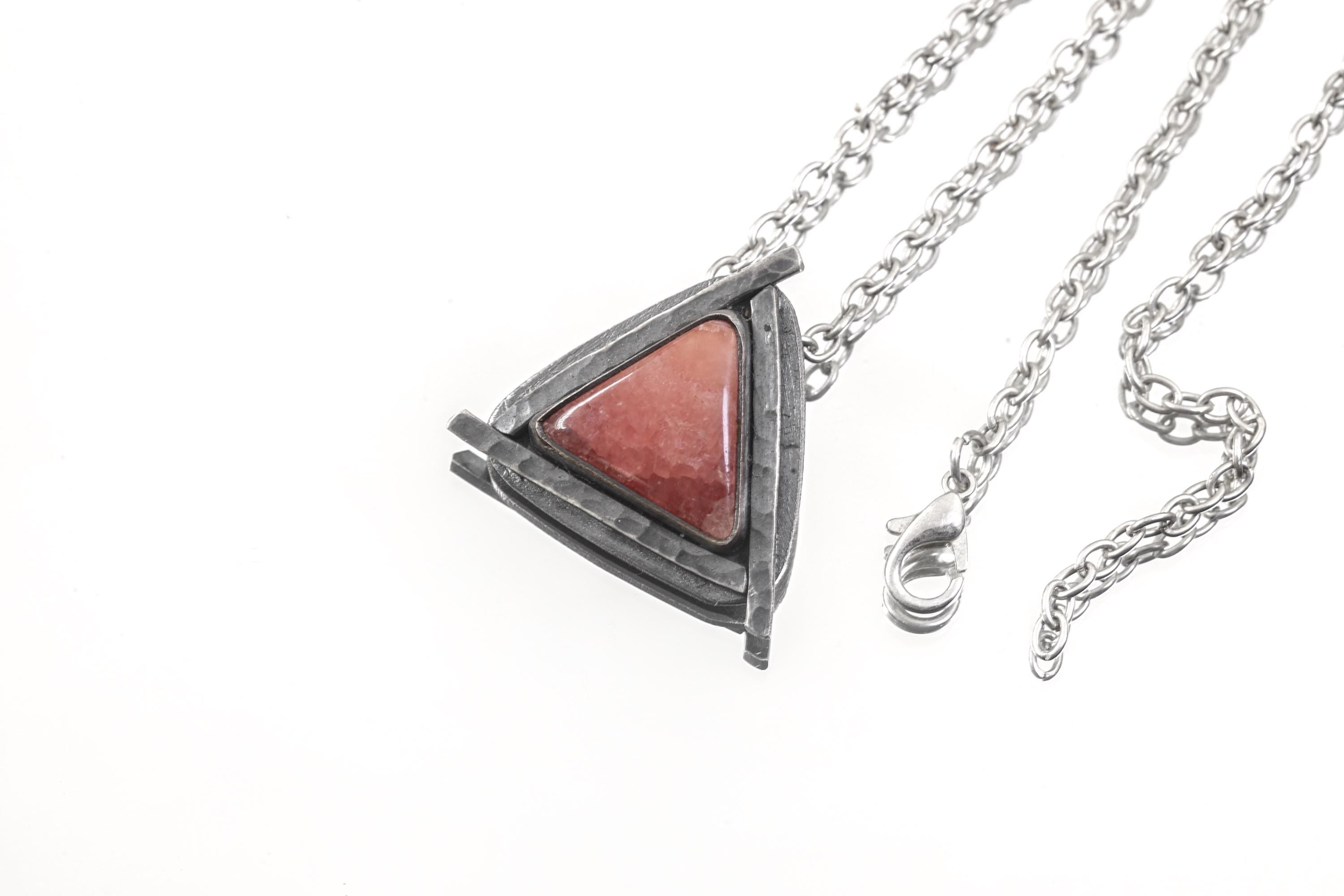 Rhodochrosite triangle pendant shown with chain on white background in oxidized sterling silver sun setting.