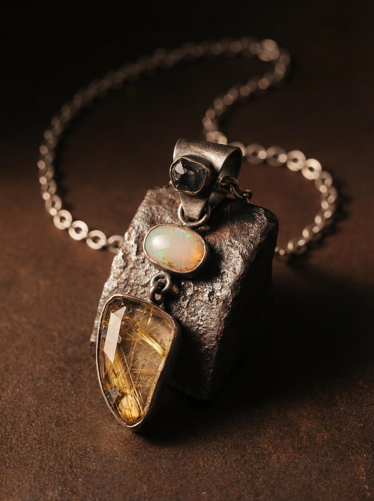 Sapphire Opal and Golden Rutile Quartz pendant shown on dark stone with oxidized sterling silver chain.