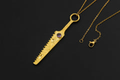 Amethyst cutter spoon pendant displayed with gold-plated brass body and chain.