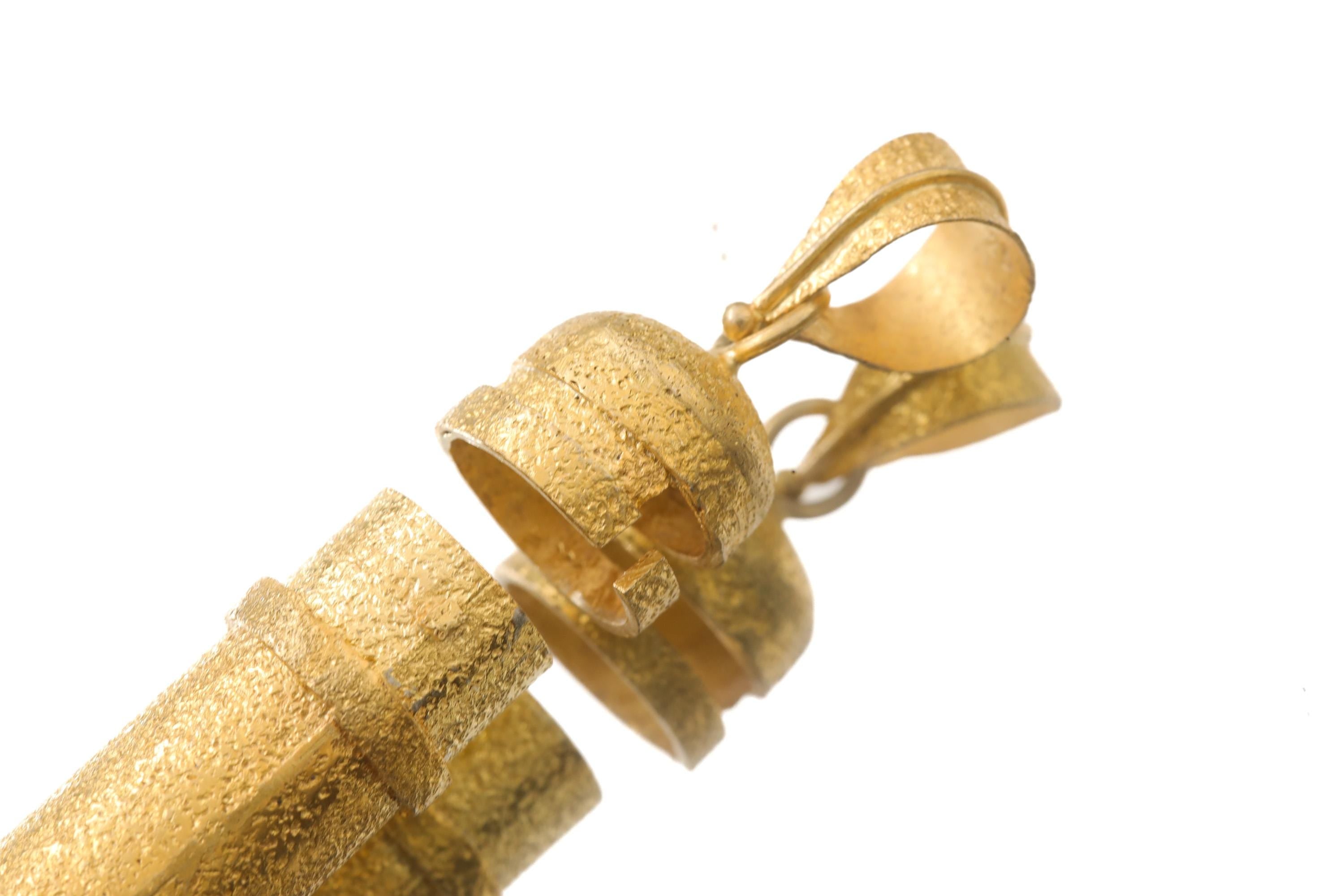 Close-up of Golden Stash pendant showing opening mechanism and textured 16k gold-plated finish.