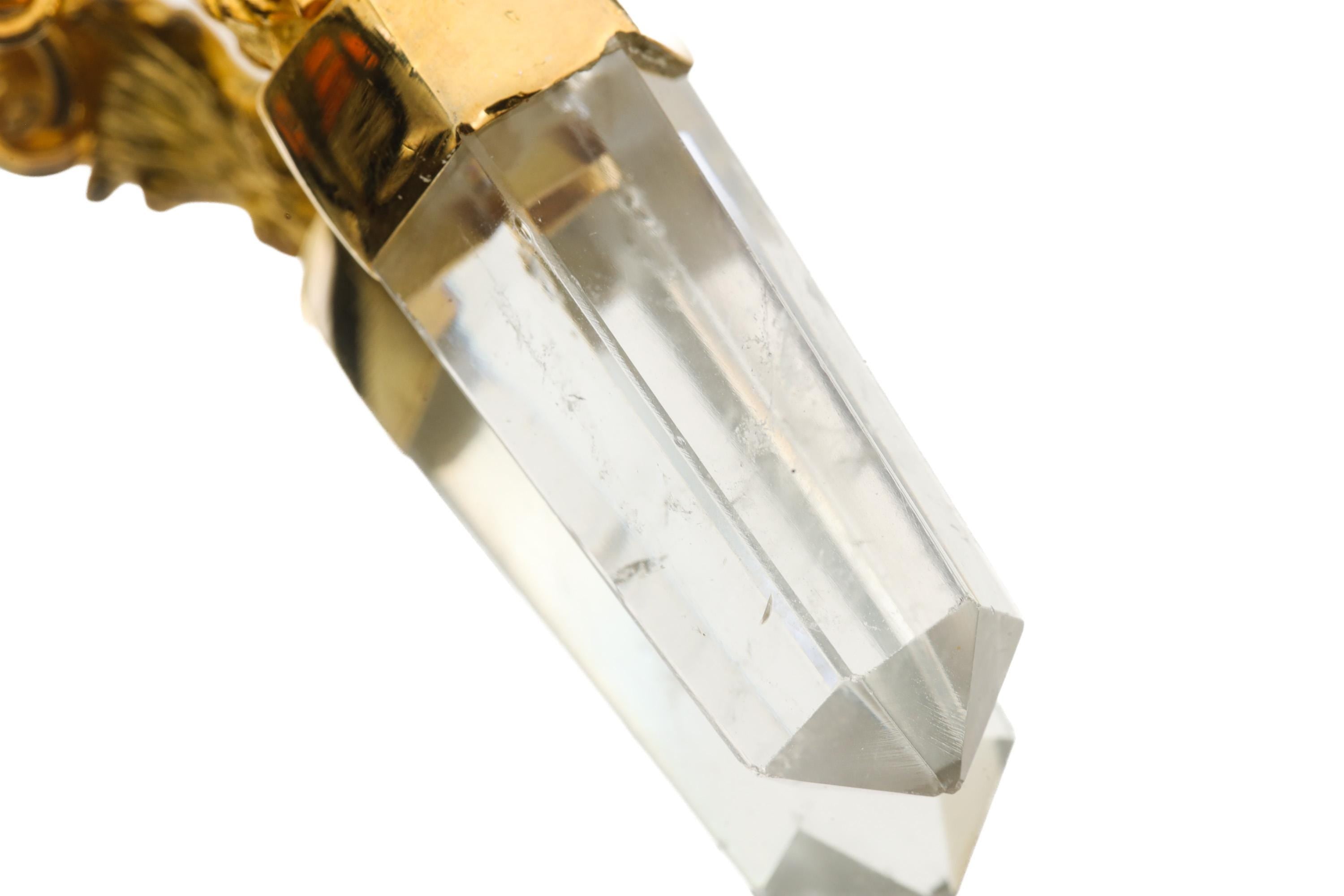 Close-up of Clear Quartz Generator Crystal in a rooster-inspired talisman pendant with gold-toned setting.