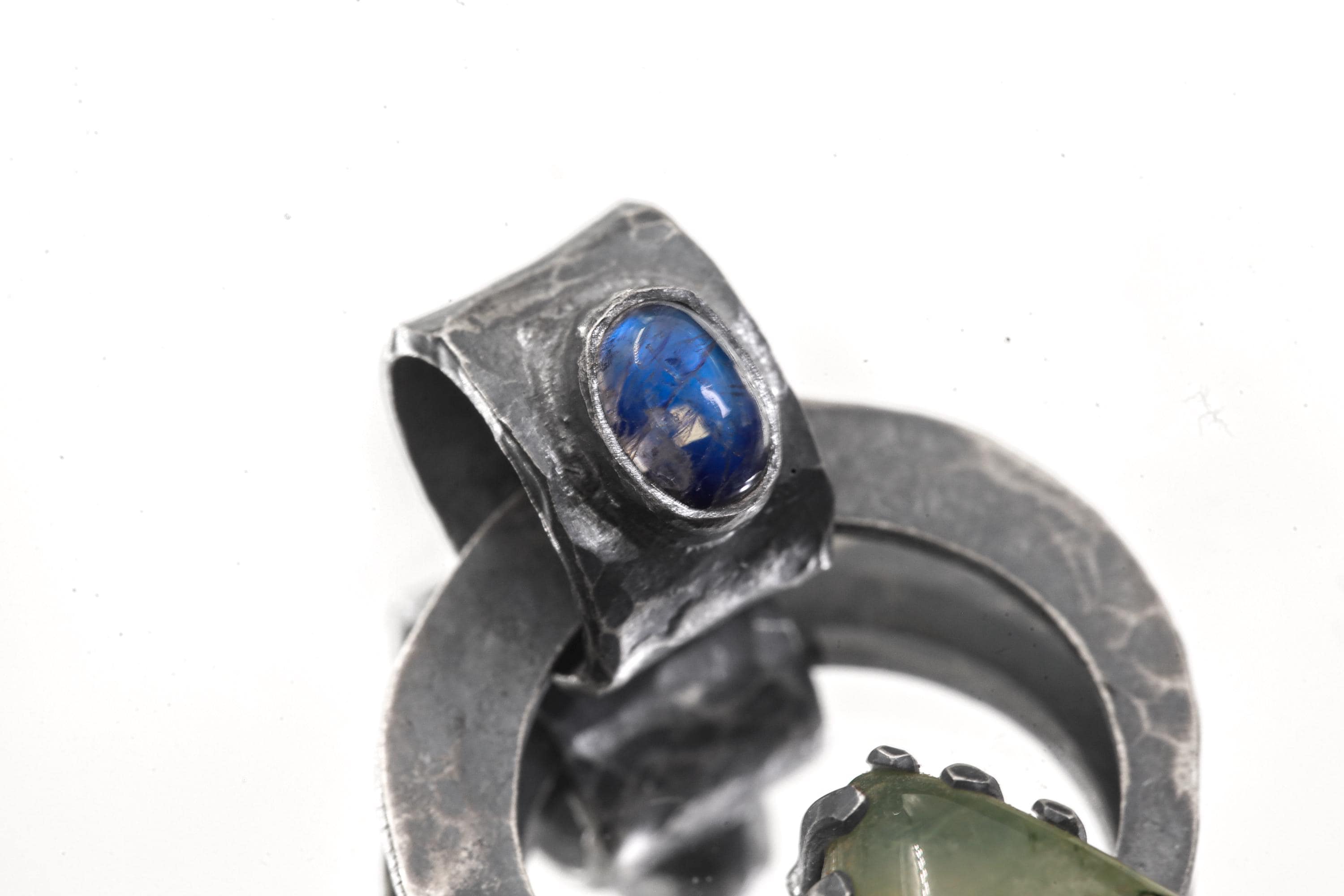 Close-up of Blue Moonstone Peridot pendant showing oxidized silver bail and blue gemstone glow.