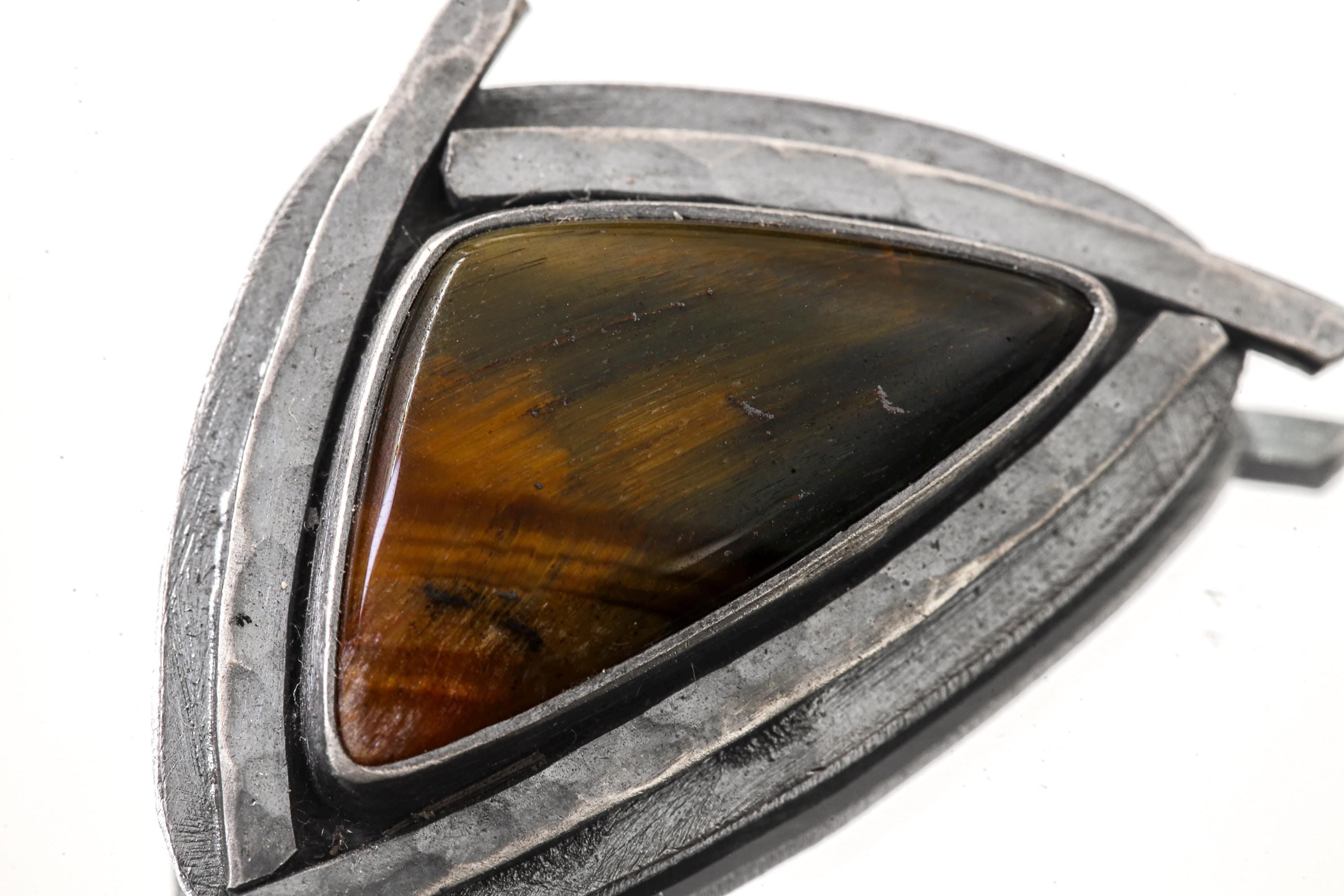 Close-up of Tiger Eye pendant showing rich brown and gold banding in handmade sterling silver frame.