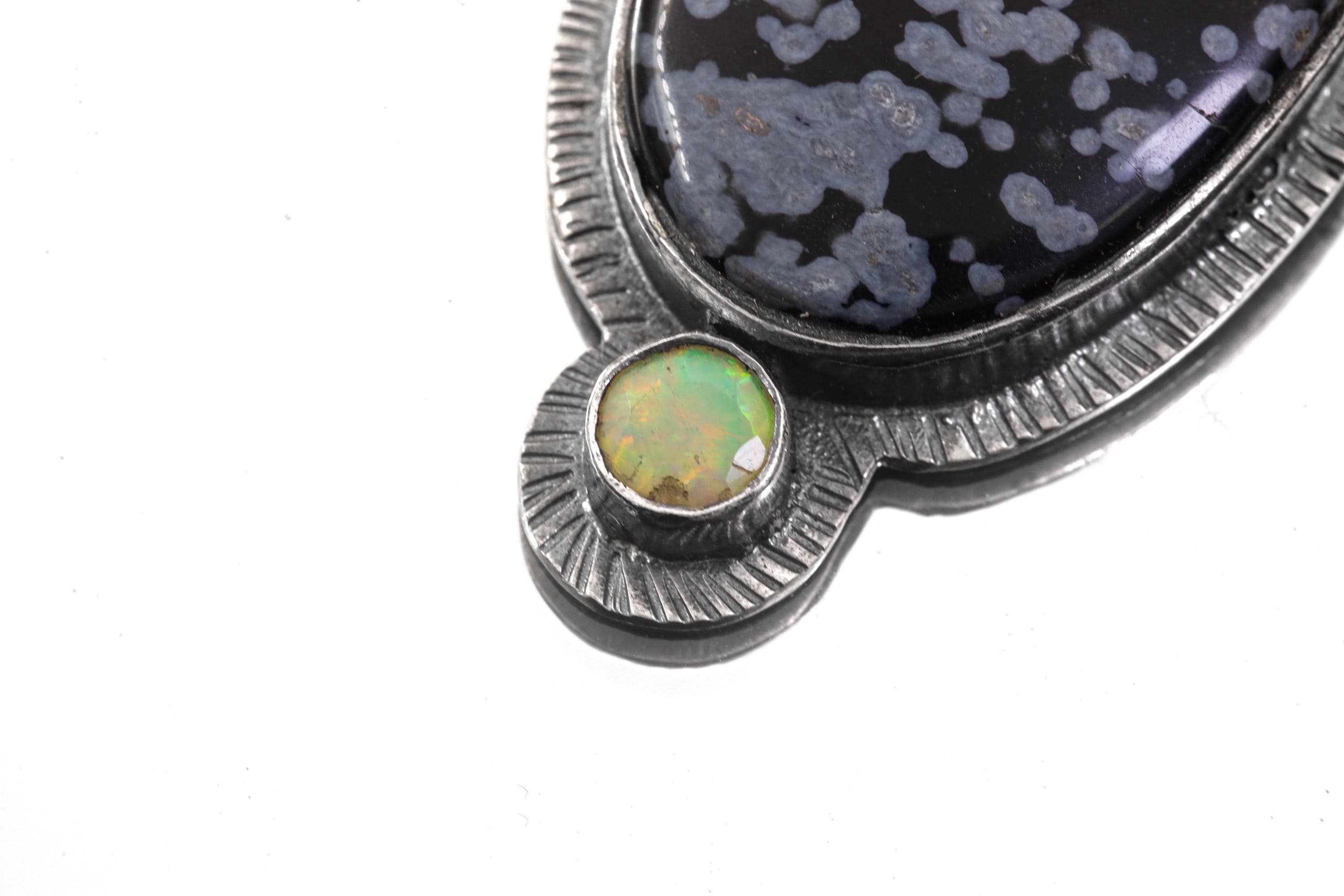 Detailed view of Ethiopian Opal accent set below Dalmatian Jasper in handmade sterling silver sun pendant.