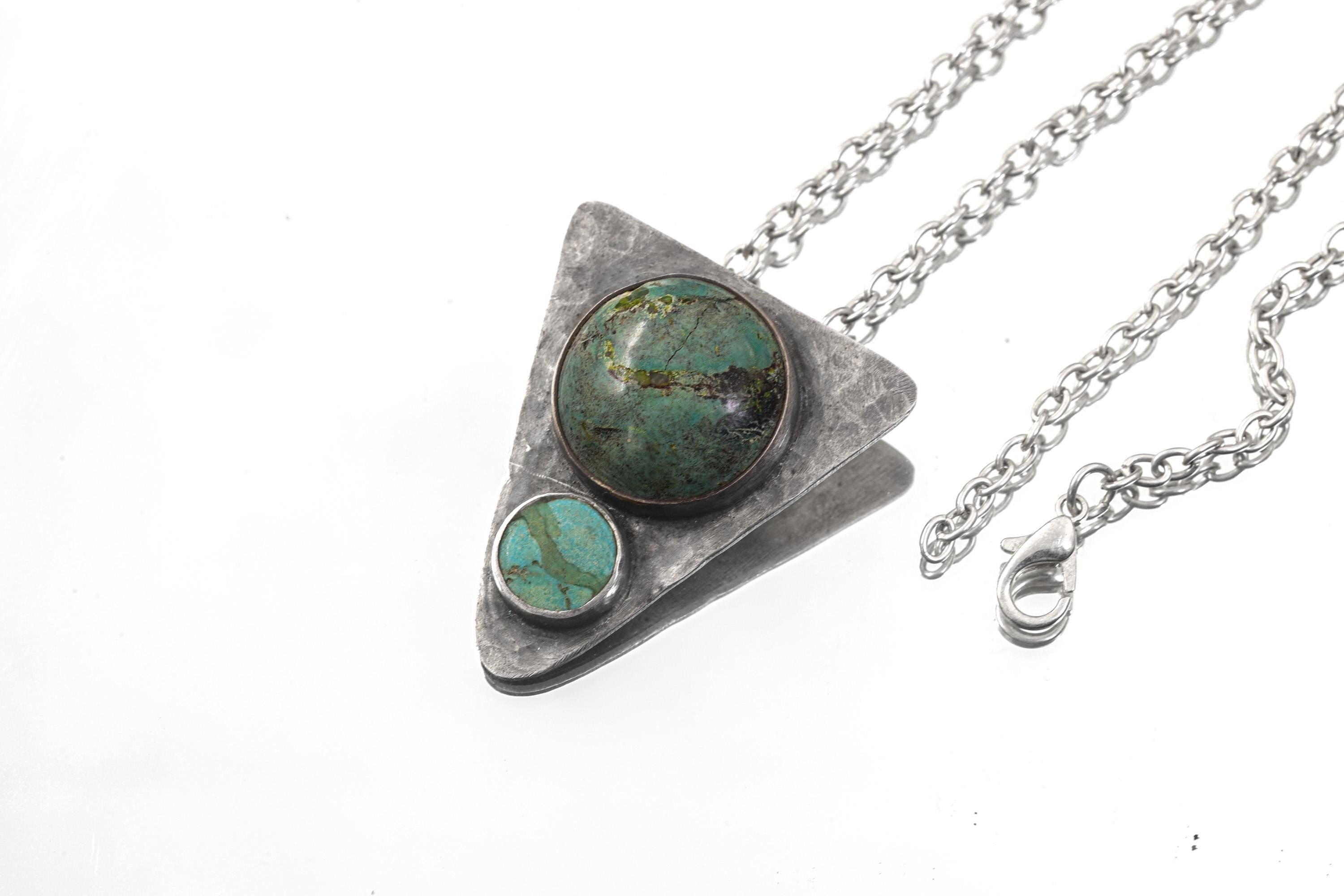 Turquoise triangle pendant shown with sterling silver chain and oxidized hammered silver setting.