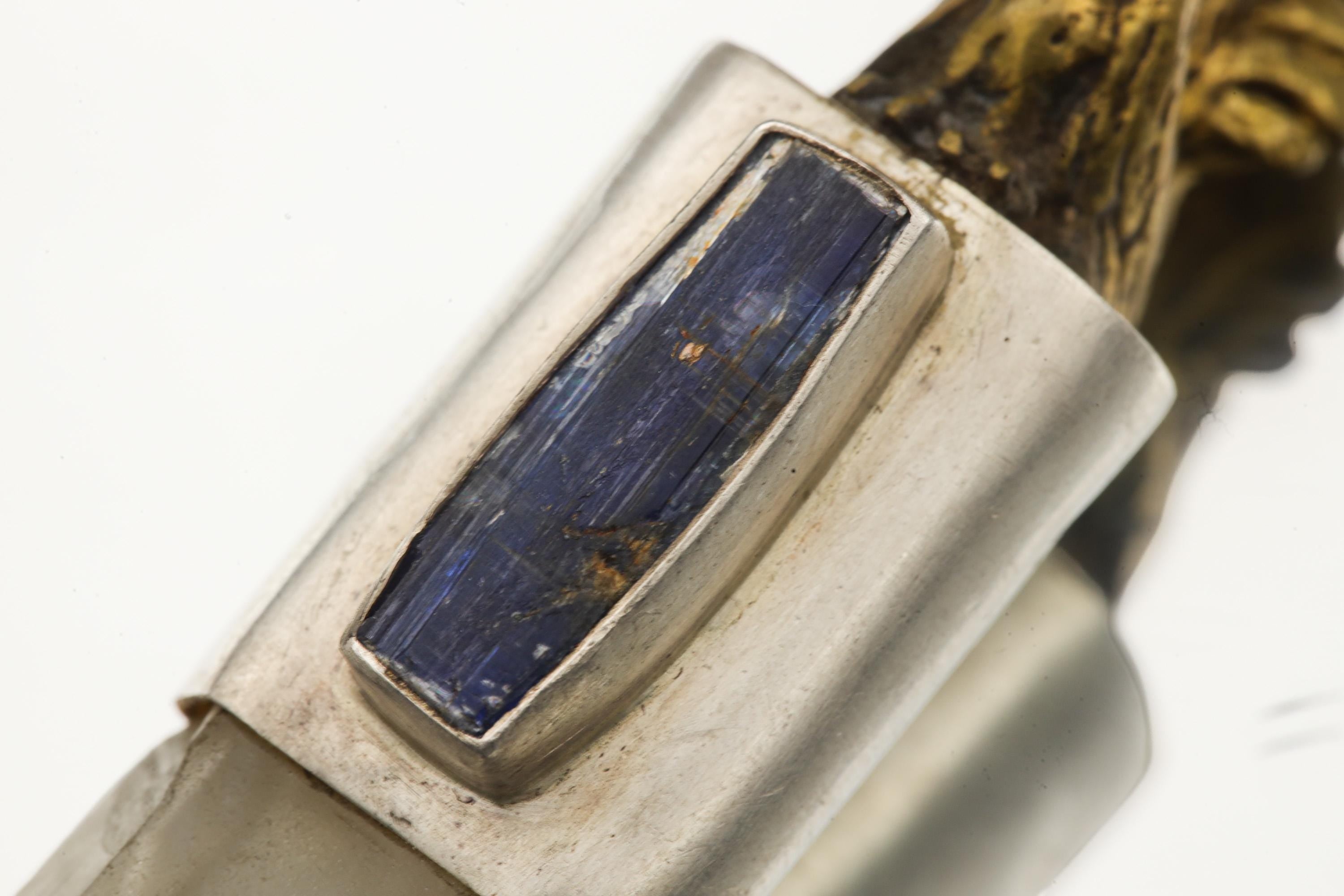 Close-up of raw deep blue Kyanite set beside Himalayan Twin-Terminated Clear Quartz in a sterling silver pendant.