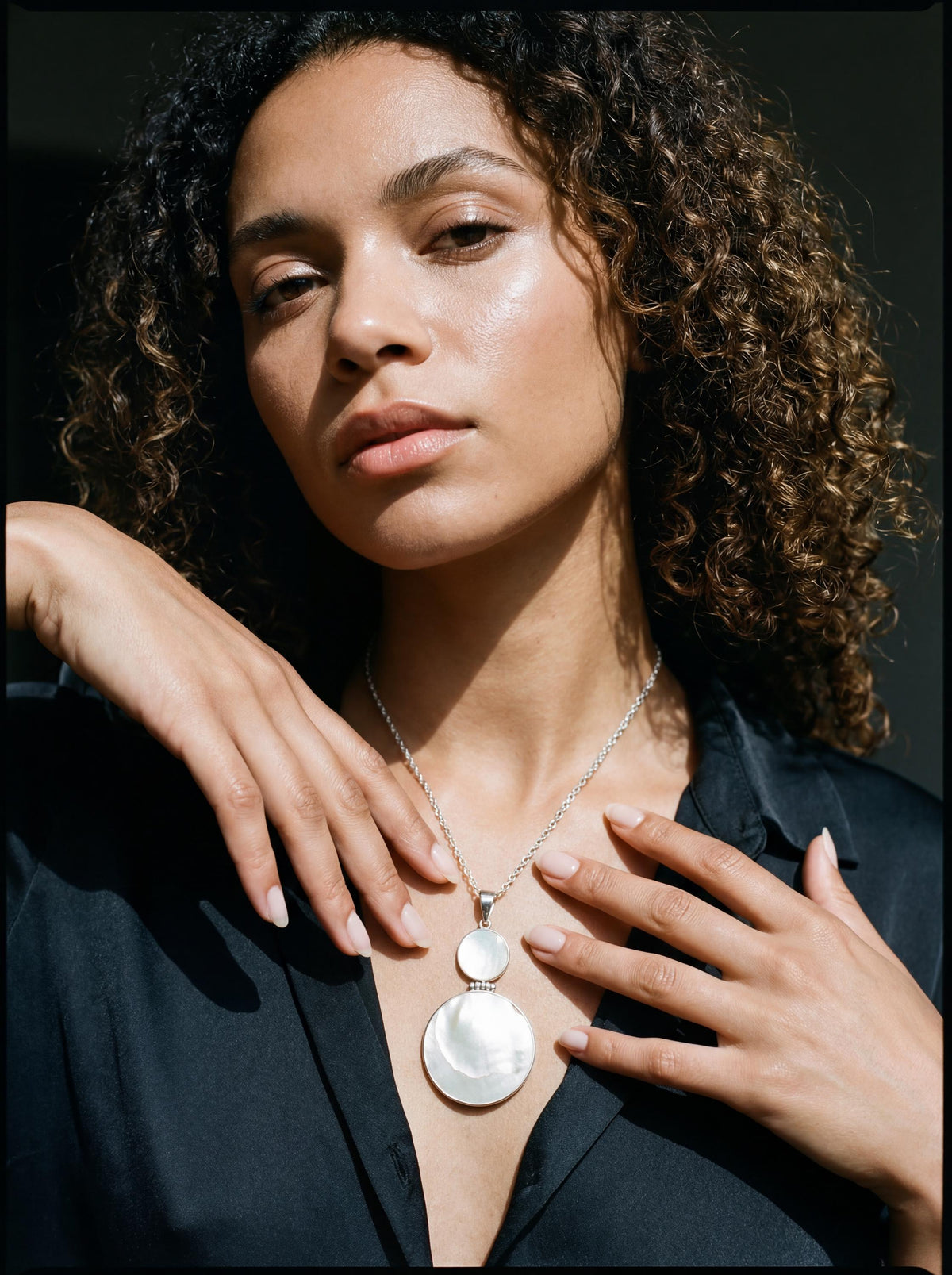 Mother of Pearl double disc sterling silver pendant shown worn on model as a luminous shell necklace.