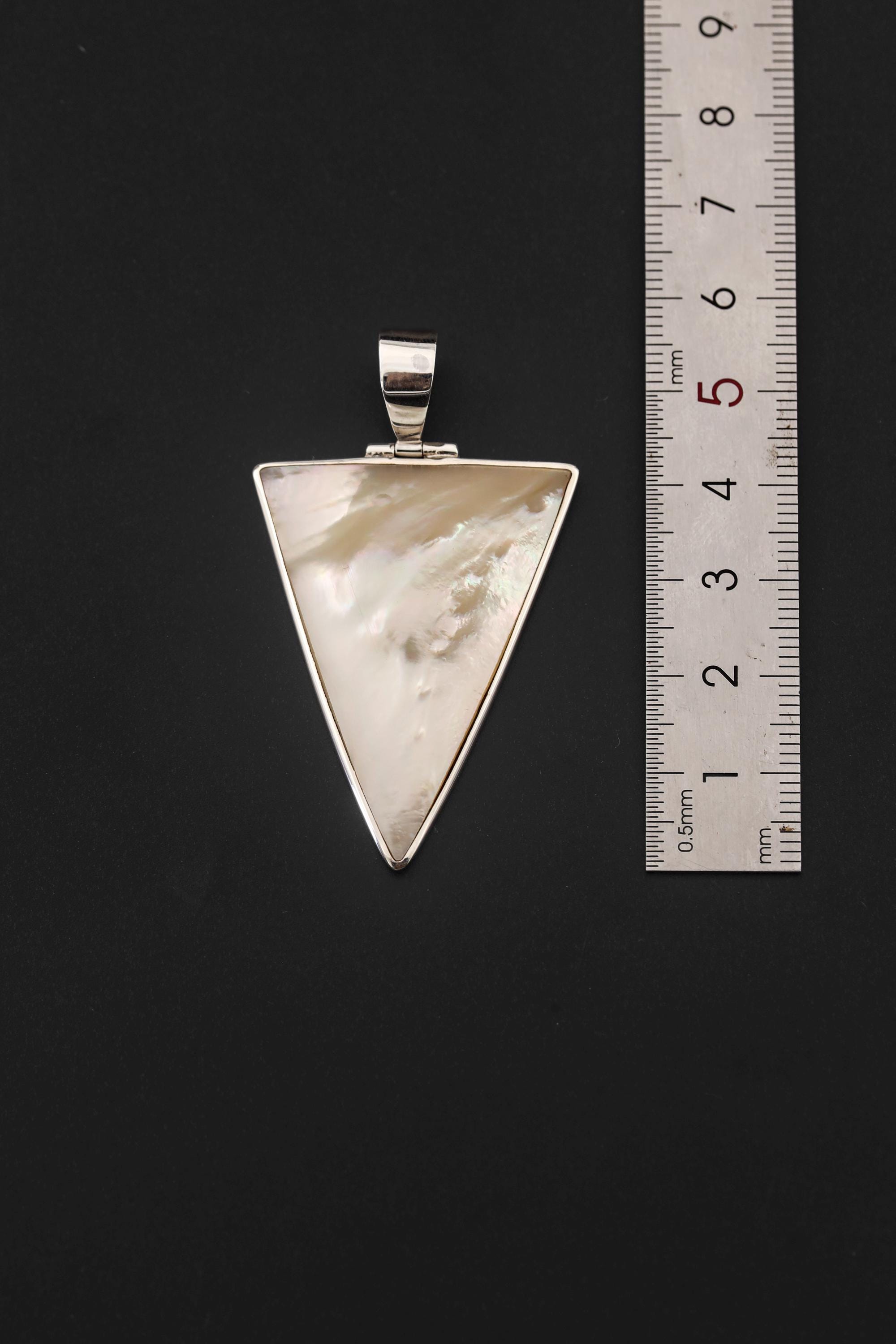 Mother of Pearl triangle pendant shown beside a ruler for pendant size reference.