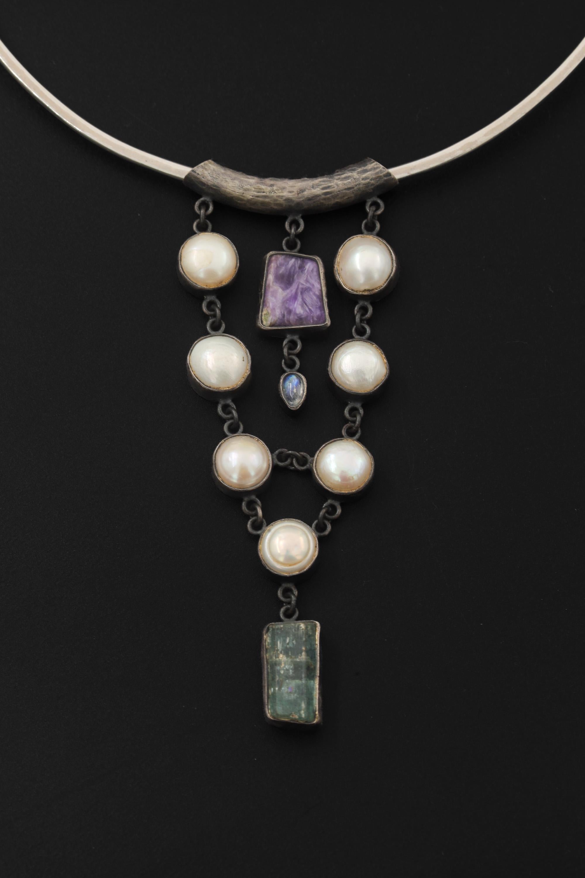 South Sea Pearl Charoite Moonstone Aquamarine pendant shown on black background with central Charoite and pearl cascade.