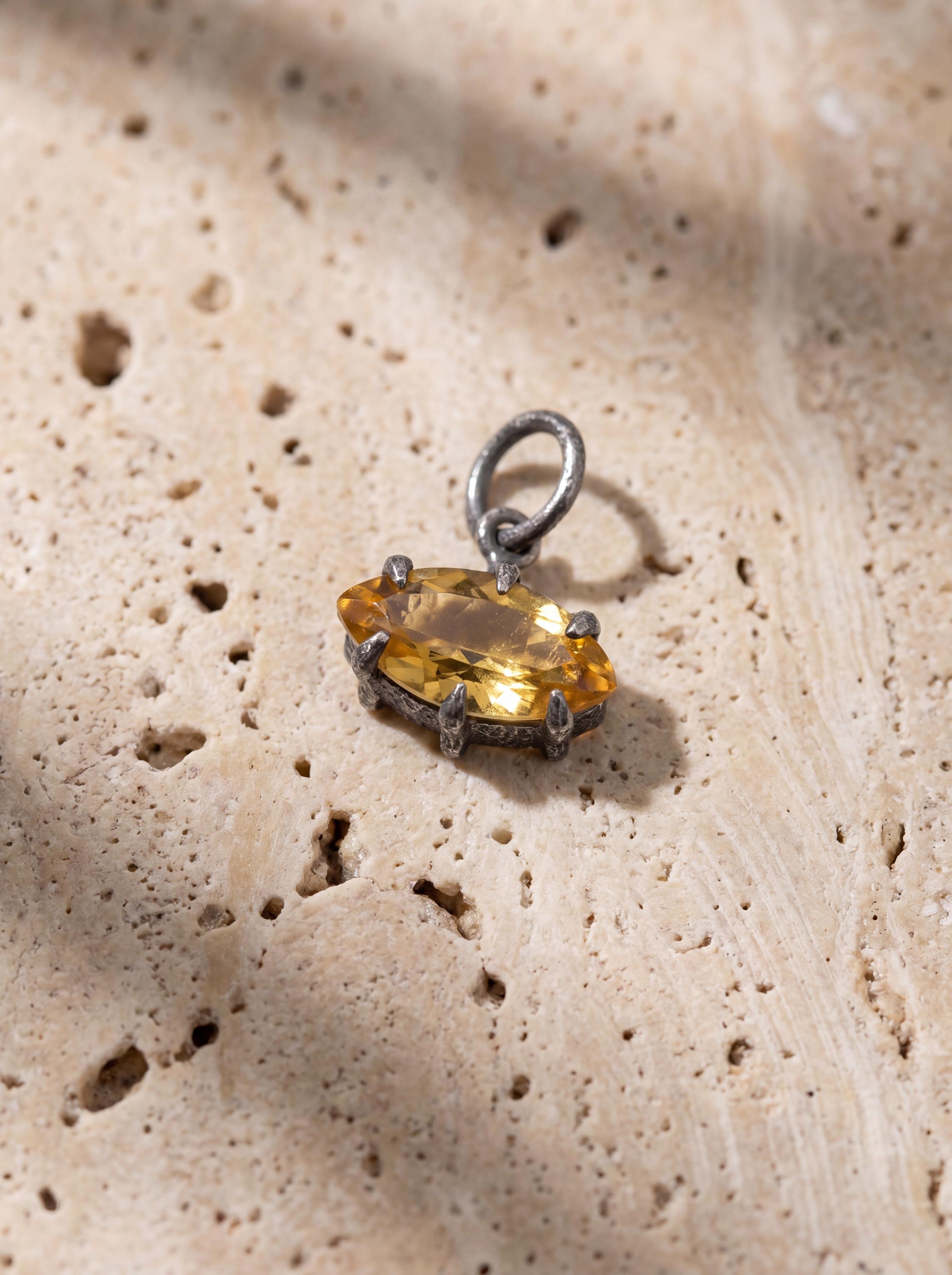 Sunspike Citrine pendant displayed on sandstone with chain and honey-gold crystal light.