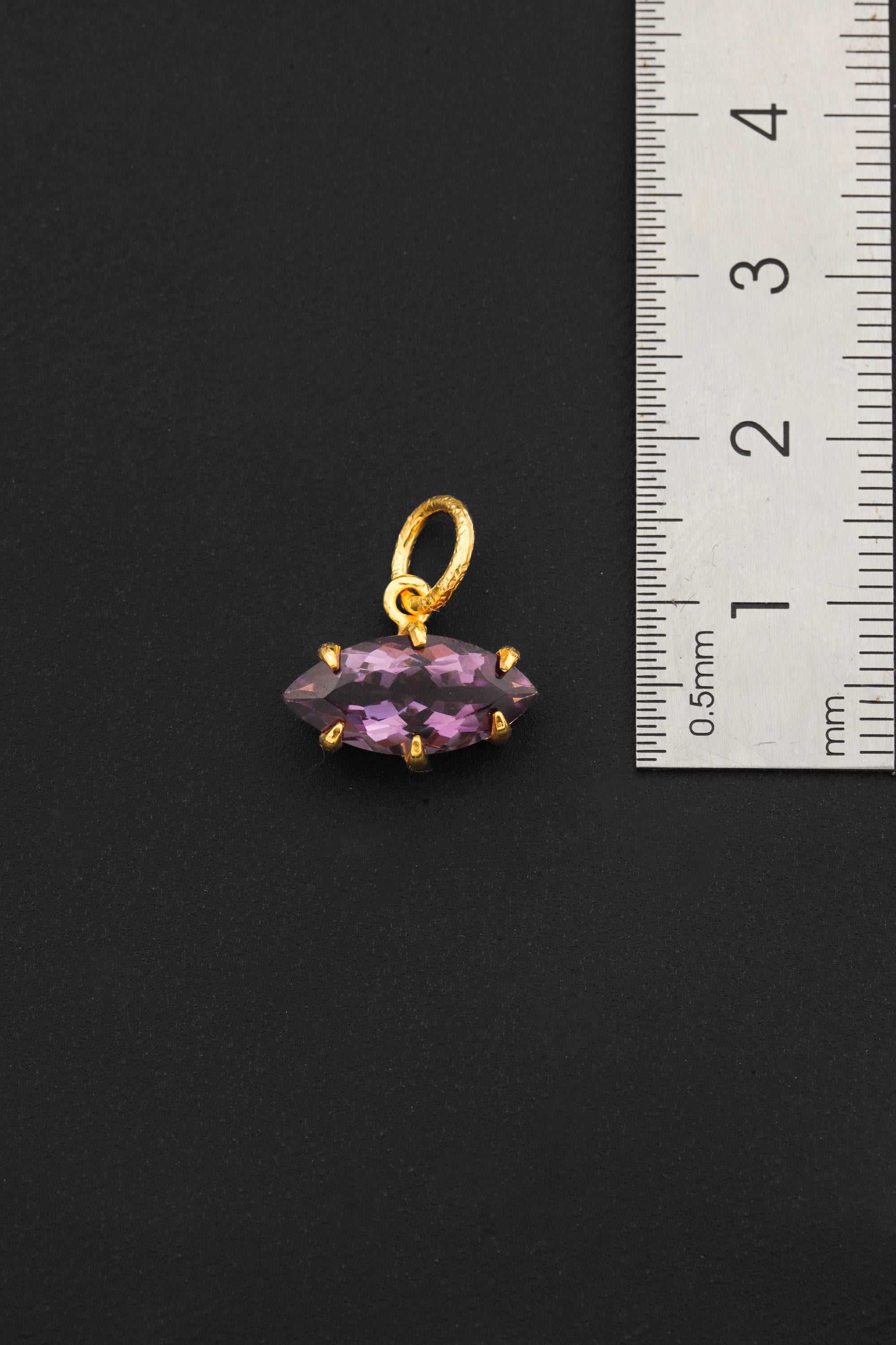 Amethyst gold-plated sterling silver pendant shown beside ruler for compact size reference.