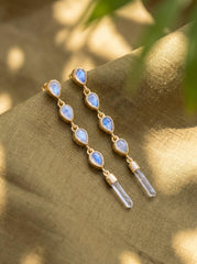 Blue Moonstone and Clear Quartz gold-plated sterling silver cascade earrings shown worn on the ear with long crystal drops.